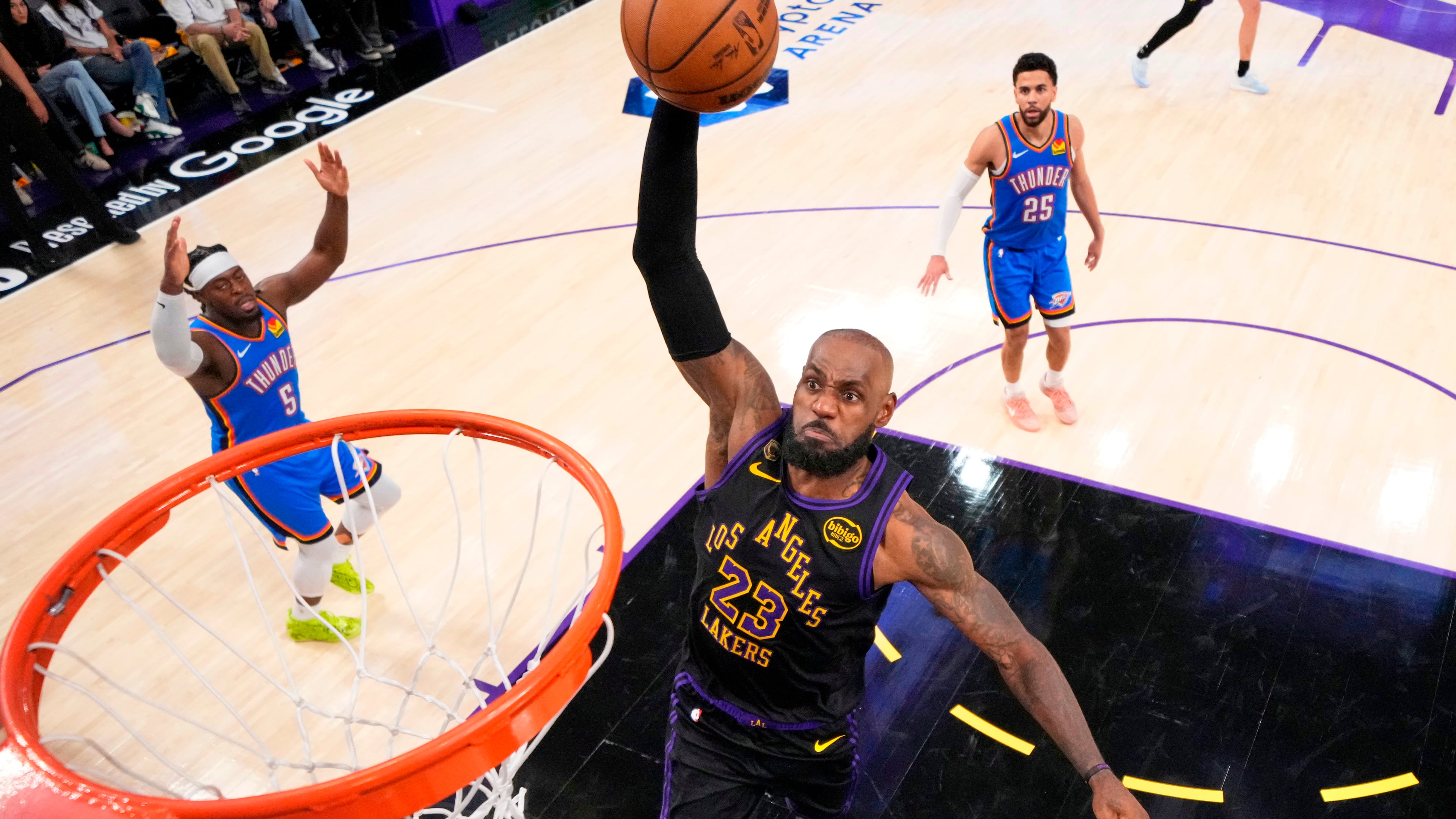 Los Angeles Lakers forward LeBron James, center, goes up for a dunk as Oklahoma City Thunder guard Luguentz Dort, left, and guard Ajay Mitchell watch during the second half of Game 4 in a second-round NBA basketball playoffs series Monday, May 11, 2026, in Los Angeles. (AP Photo/Mark J. Terrill)