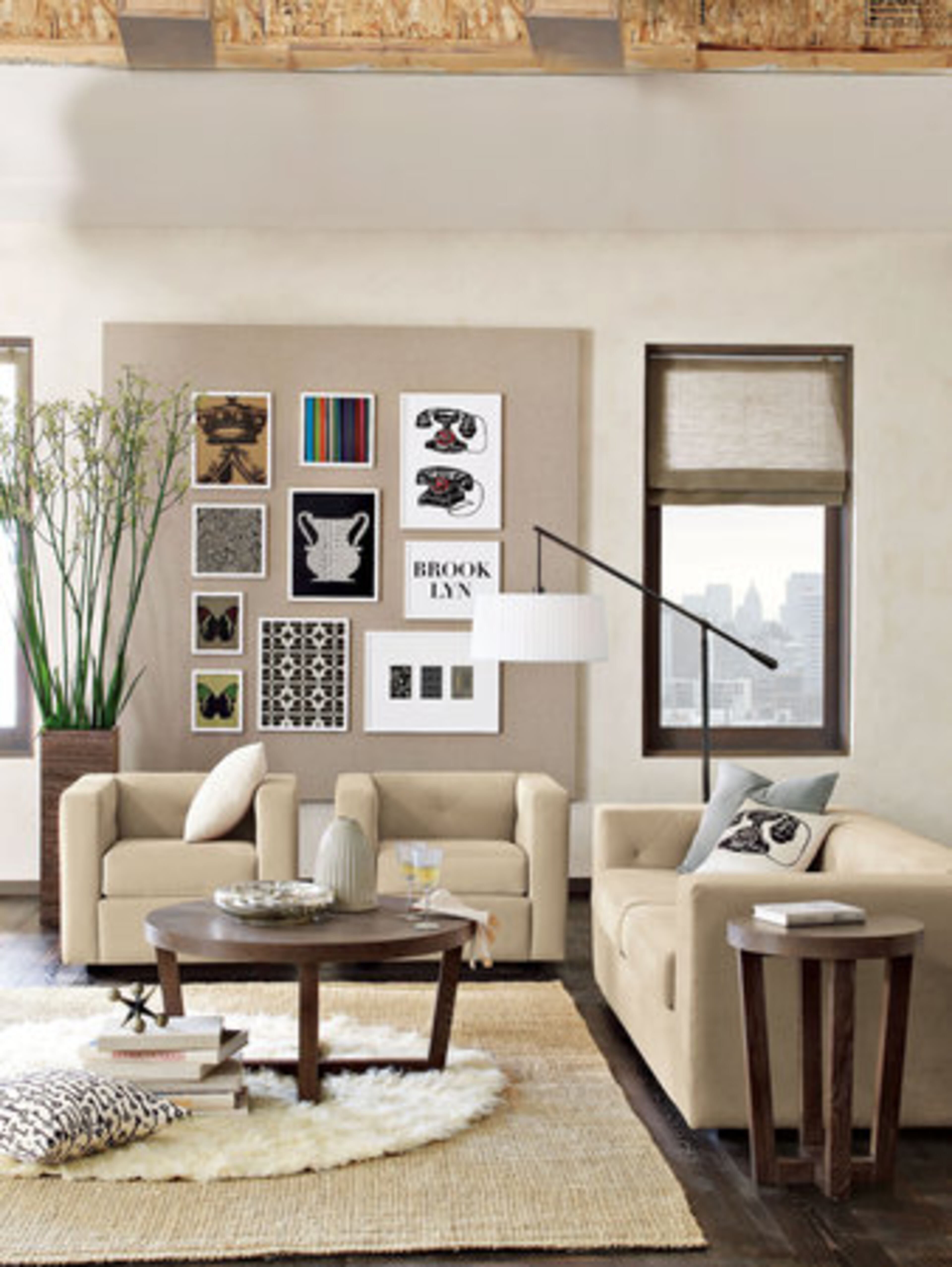 This floor lamp ($249, West Elm) with a drum-style pleated shade hikes the room's hip quotient. Another great idea is the way the art is displayed. There are several small pieces of art, but the impact is big because they are hung on a larger background. You can achieve a similar look with a piece of plywood, a staple gun and stable fabric that won't stretch out of shape. Add your existing art, frame pictures from a coffee table book or magazine. ($14-$19 art, 12-$44 frames, West Elm).