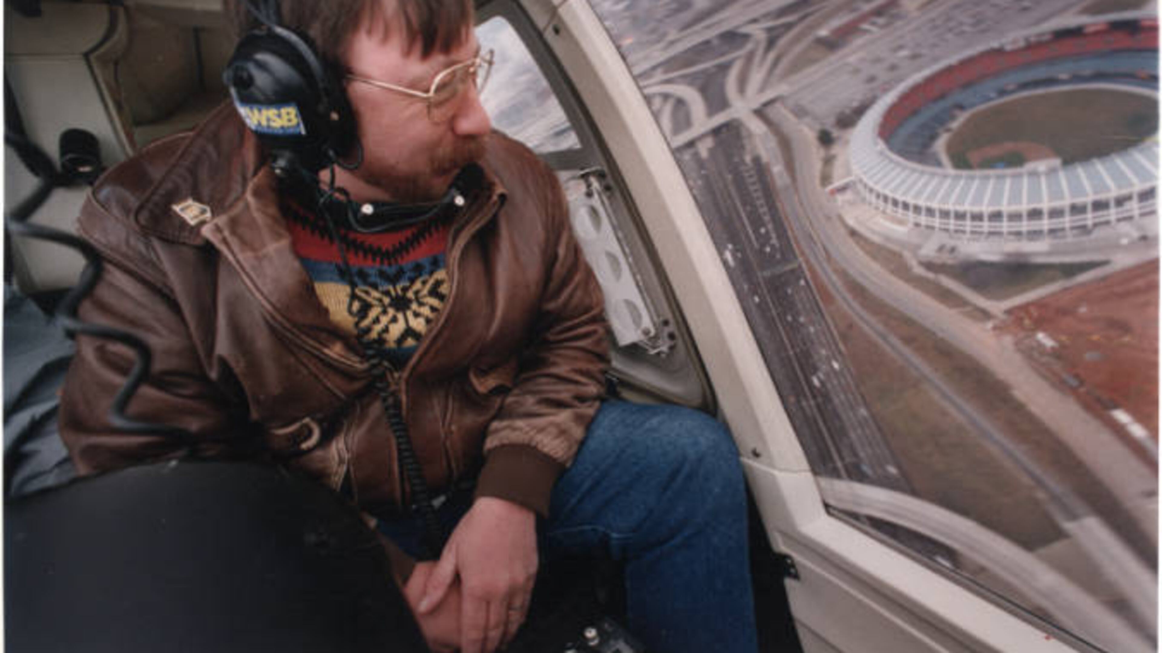 Traffic reporter, Herb Emory, from WSB Radio, giving a traffic report from a helicopter. Atlanta-Fulton County Stadium sits in the background, Atlanta, Georgia, January 3, 1994. AJC FILE PHOTO