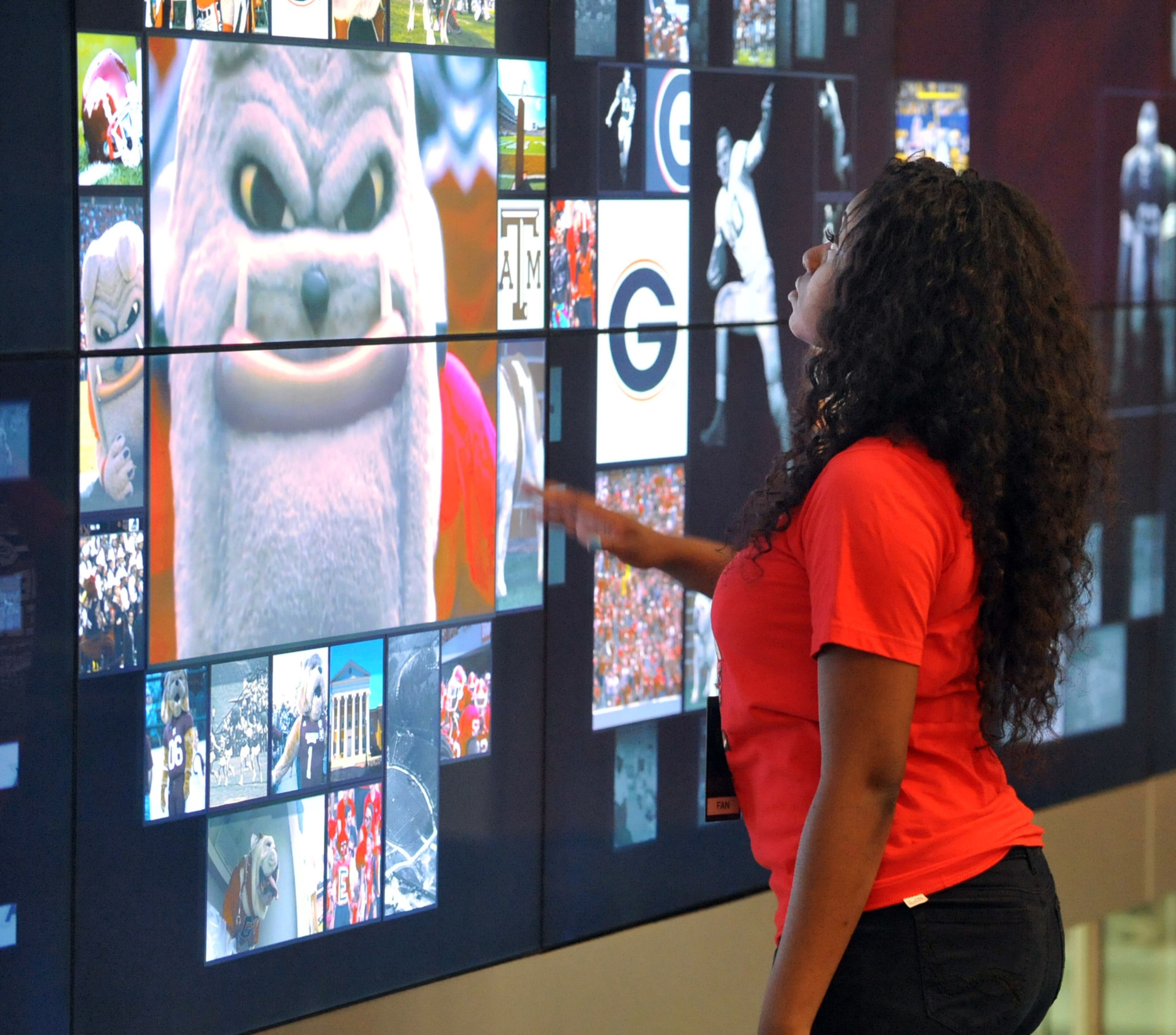 Fan ambassador Shannon Reynolds uses an interactive 52-foot touchscreen to show photos and video of the University of Georgia. The wall is RFID-enabled for visitors and will display their favorite teams upon entering.