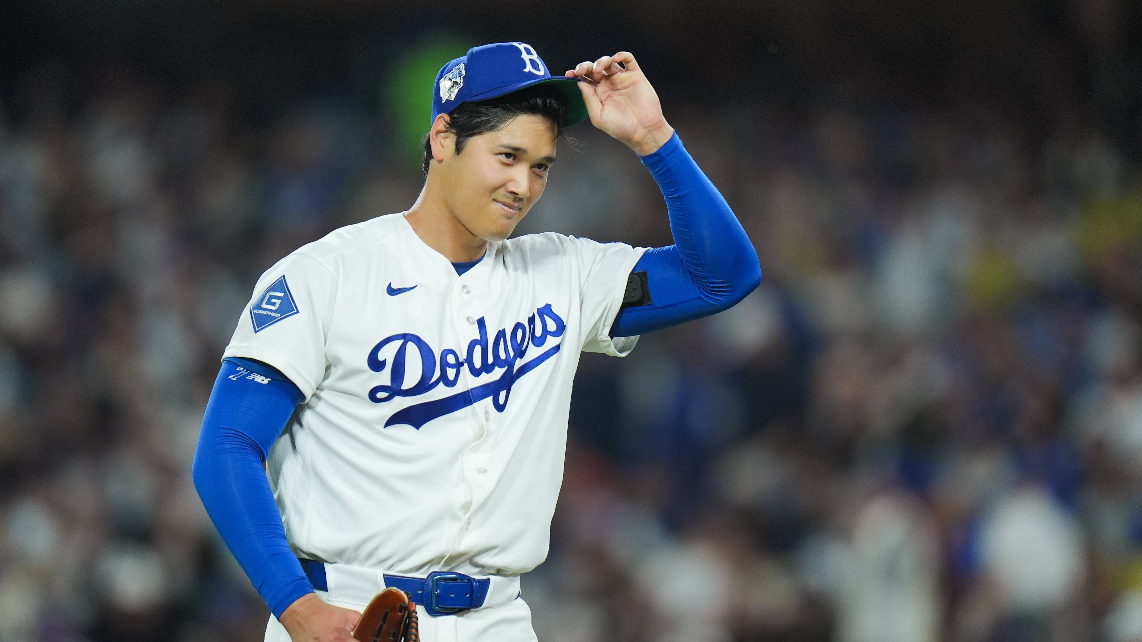 Los Angeles Dodgers starting pitcher Shohei Ohtani adjusts his hat as he walks off the field after the third inning of a baseball game against the New York Mets Wednesday, April 15, 2026, in Los Angeles. (AP Photo/Jae C. Hong)