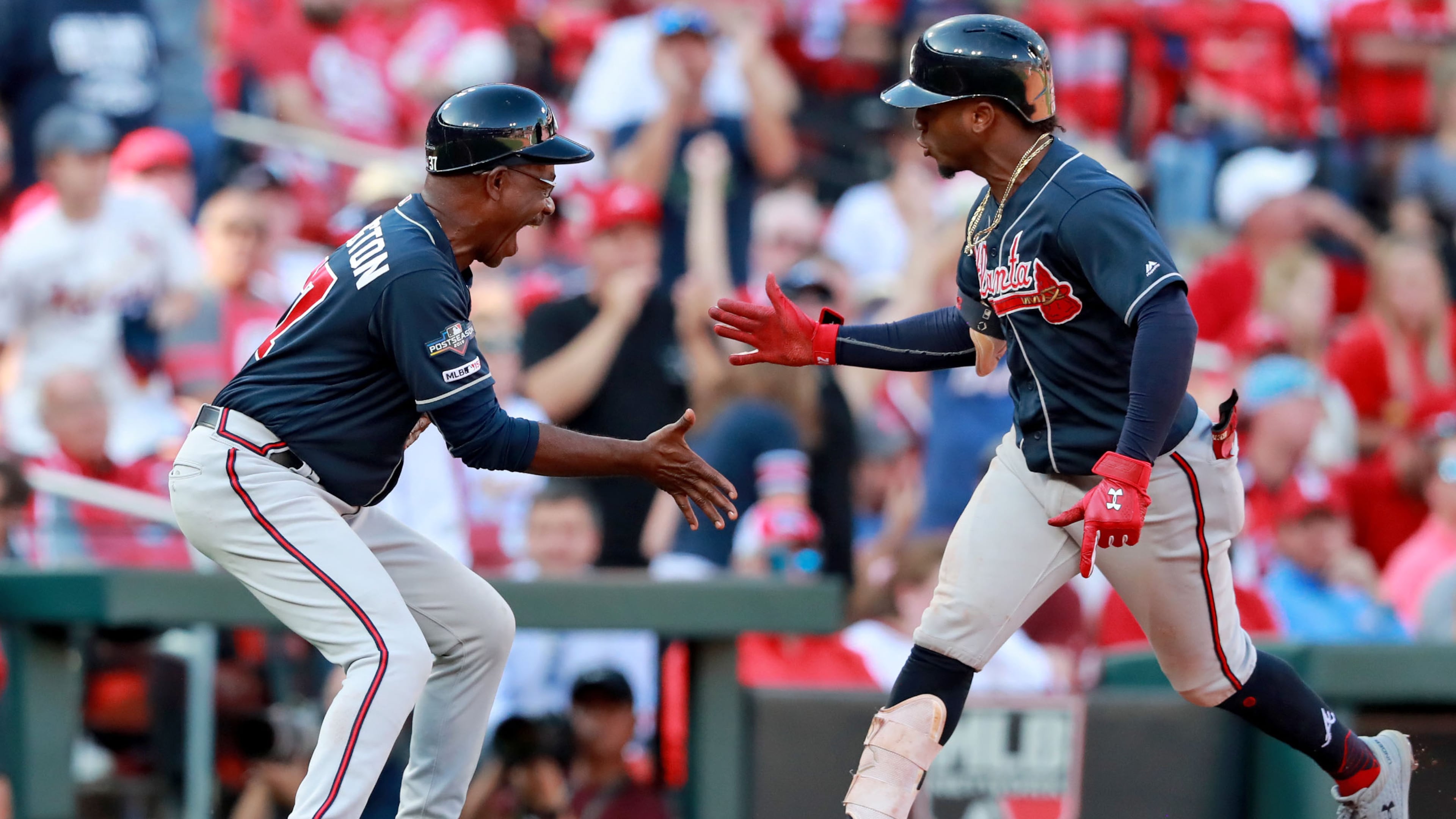 Ozzie Albies (right) celebrates with third base coach Ron Washington as he rounds third and heads home following his home run in Monday's Game 4 of the National League Division Series in St. Louis.