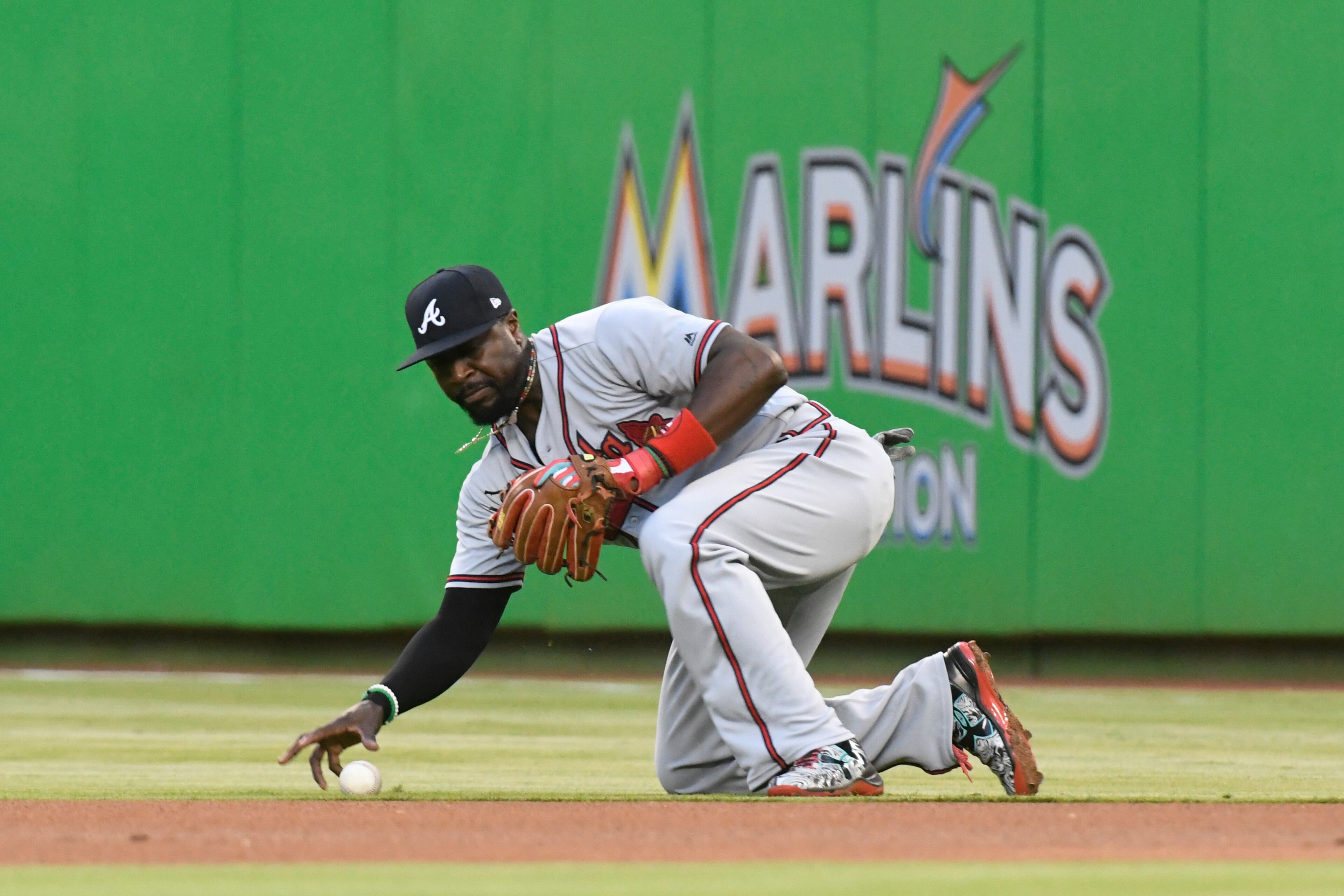 MIAMI, FL - MAY 12: Brandon Phillips #4 of the Atlanta Braves picks up the baseball after a sharp line drive off the bat of Christian Yelich #21 of the Miami Marlins during the first inning of the game at Marlins Park on May 12, 2017 in Miami, Florida. (Photo by Eric Espada/Getty Images)