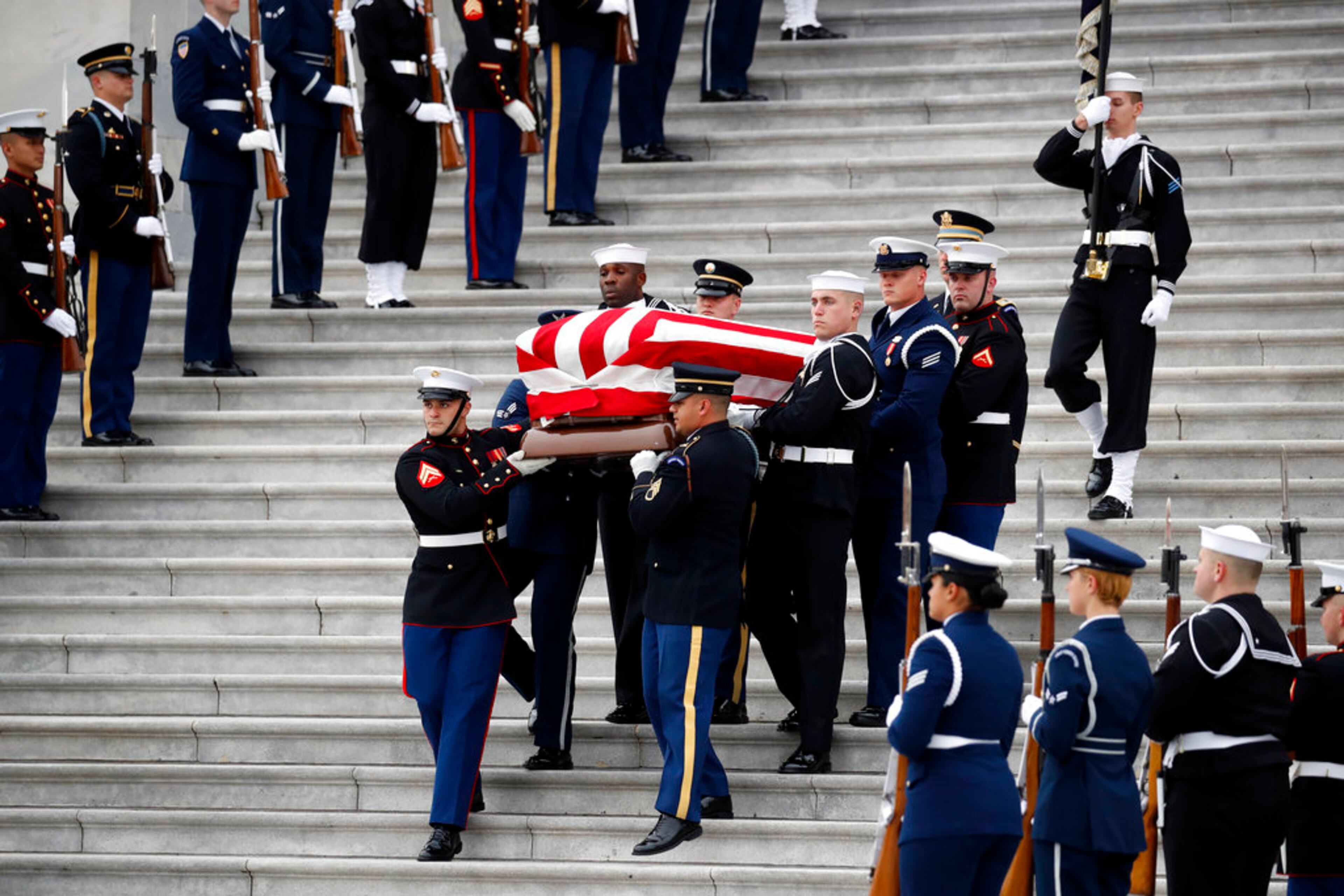 The flag-draped casket of former President George H.W. Bush is carried by a joint services military honor guard from the U.S. Capitol, Wednesday, Dec. 5, 2018, in Washington. (AP Photo/Alex Brandon, Pool)