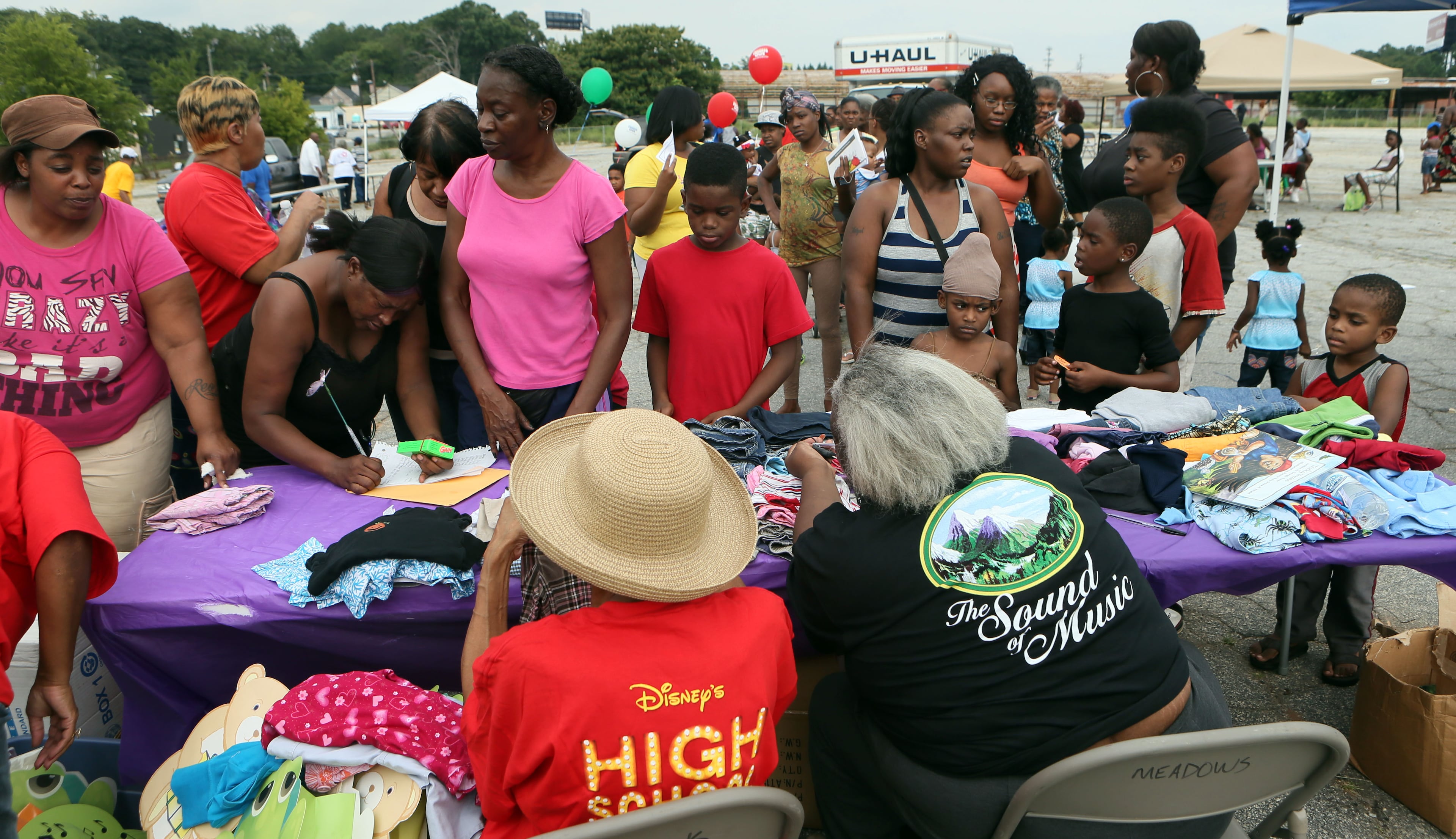 Families crowded the Pittsburg Ministerial Alliance booth for free clothes & supplies during the 30th anniversary of National Night Out in the Pittsburg area of Atlanta on Tuesday.