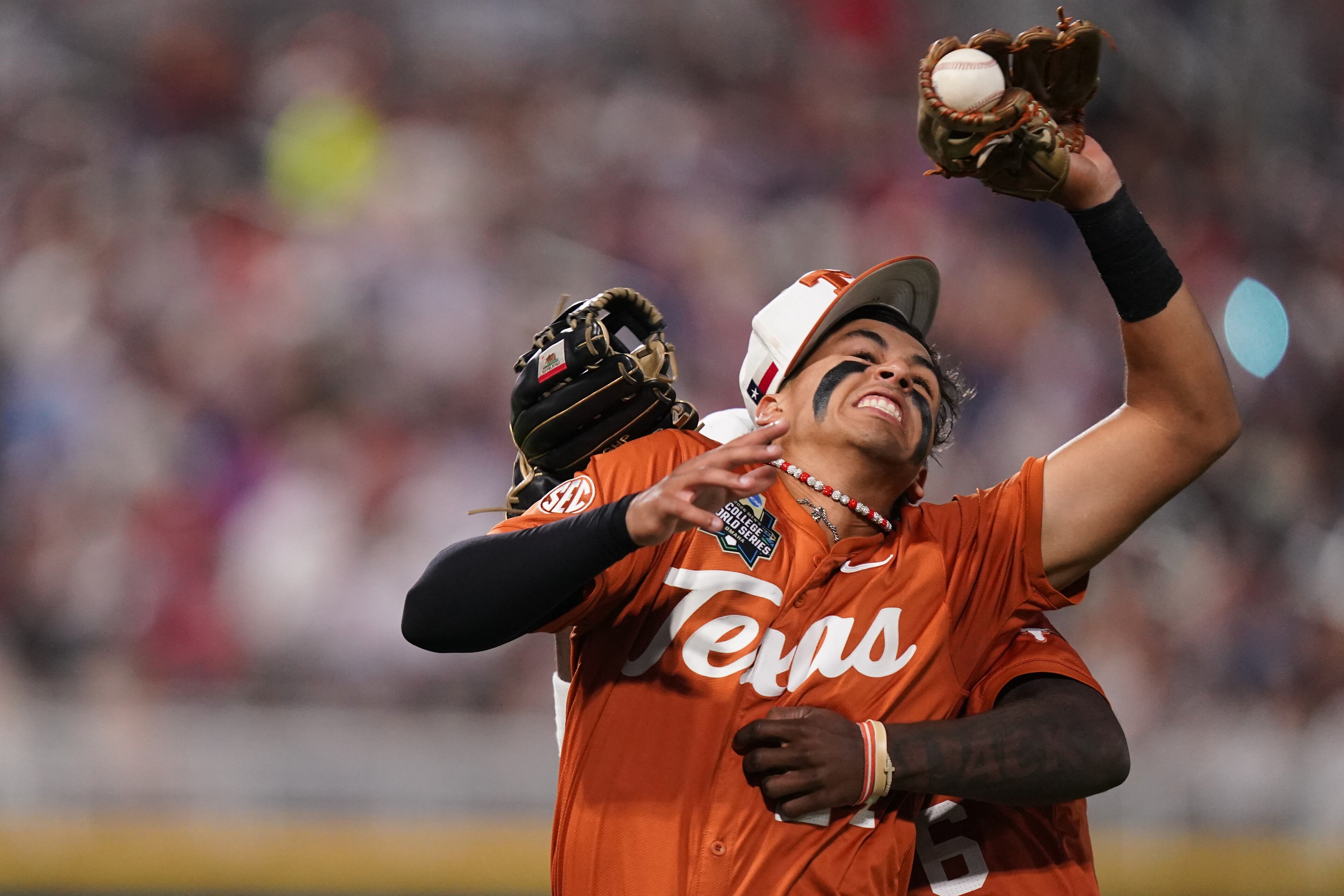 Texas infielder Adrian Rodriguez (24) makes the catch while colliding with outfielder Anthony Pack Jr. (6) during an NCAA baseball College World Series elimination game against Georgia, Tuesday, June 16, 2026 in Omaha, Neb. Georgia won 2-0. (AP Photo/Vera Nieuwenhuis)