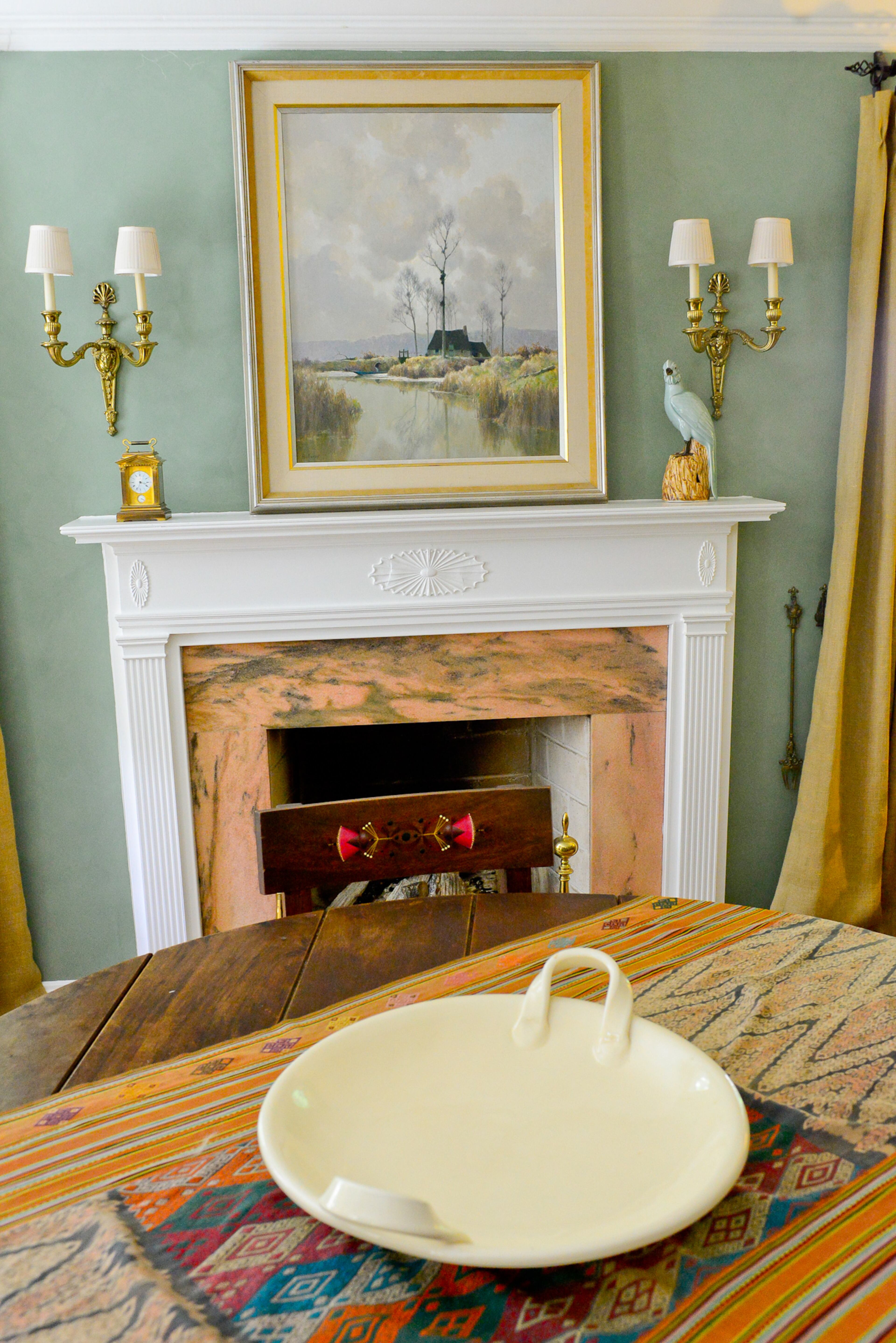 Over the fireplace, a painting from Switzerland was a gift from family. The pink marble on the fireplace is mined in Georgia.