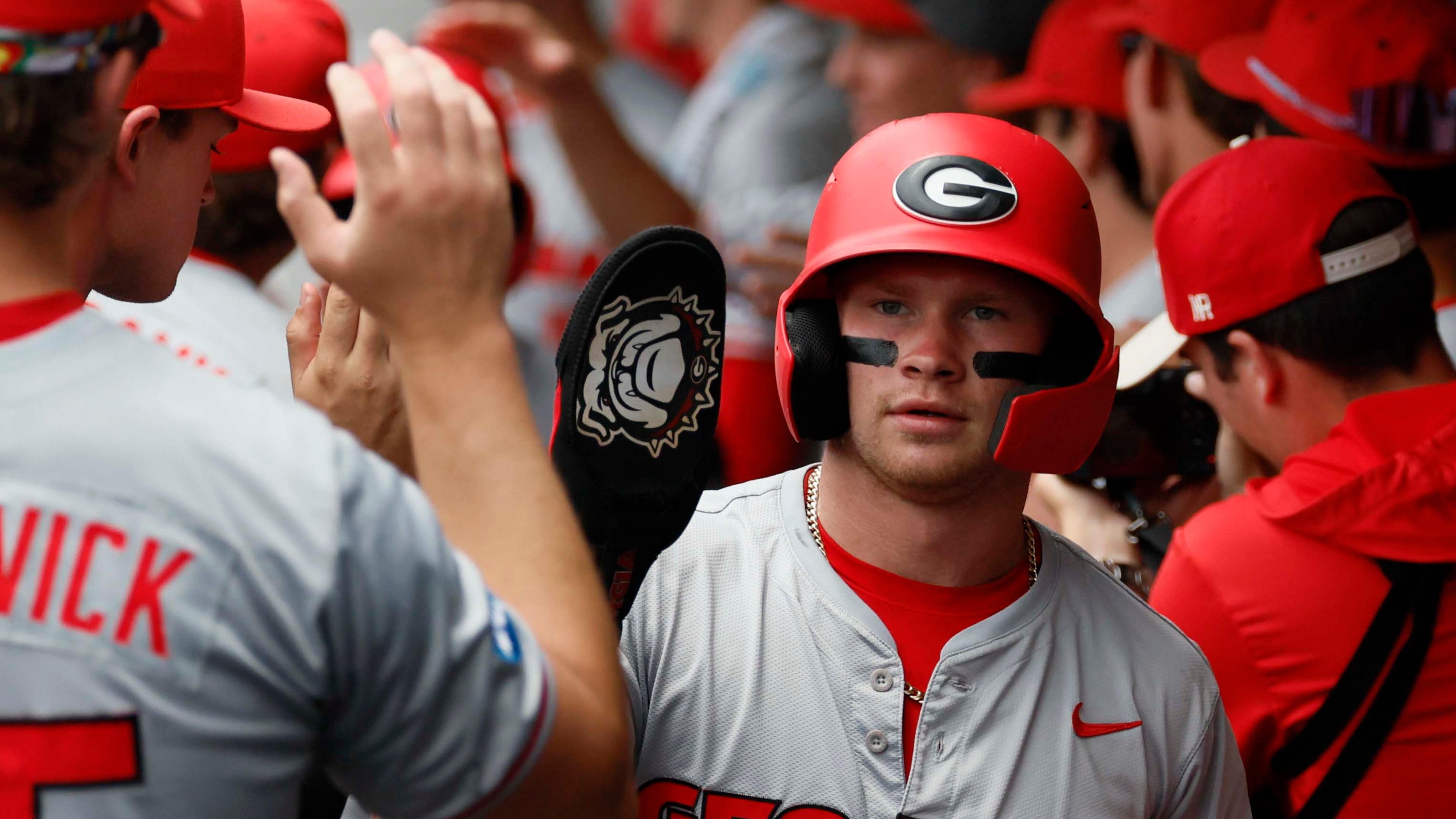 Georgia Bulldogs catcher Daniel Jackson high-fives teammates after scoring during the first inning of Game 2 of the NCAA Super Regional at Foley Field on Sunday, June 7, 2026, in Athens. (Miguel Martinez/AJC)