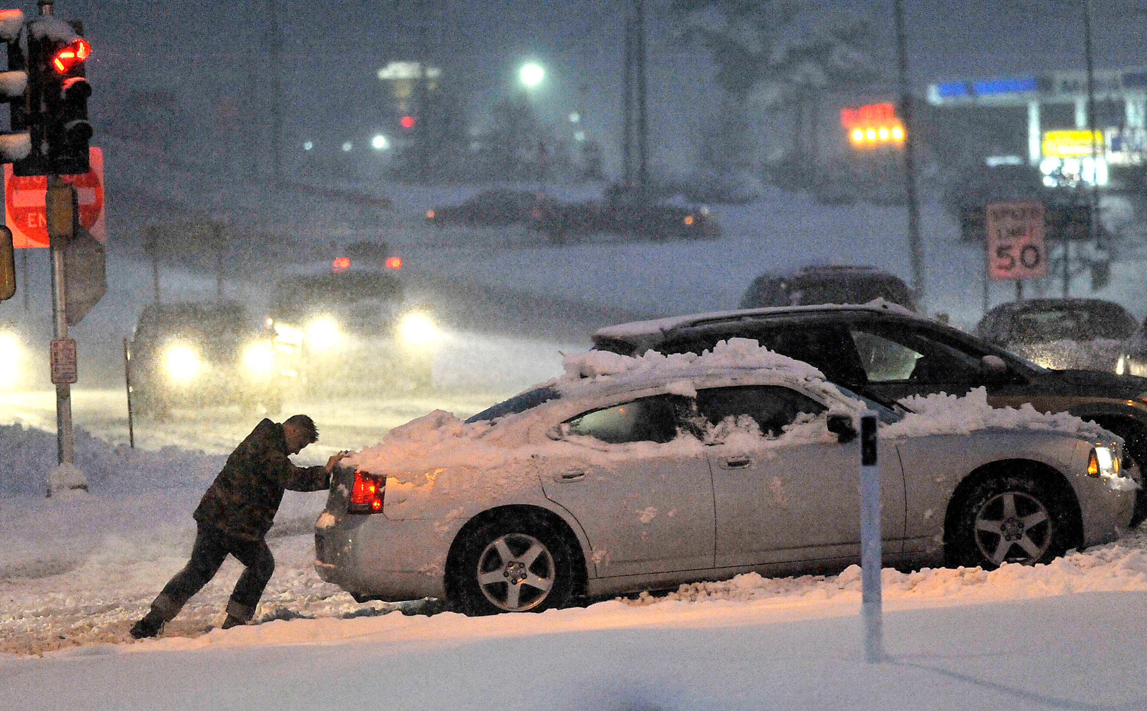 A motorist helps another vehicle stuck in the snow near the intersection of Highway 50 and Highway 31 in Kenosha, Wis., Thursday, Feb. 7, 2013. Unofficial snowfall totaled over seven inches near the Lake Michigan shoreline. (AP Photo/Kenosha News, Brian Passino)