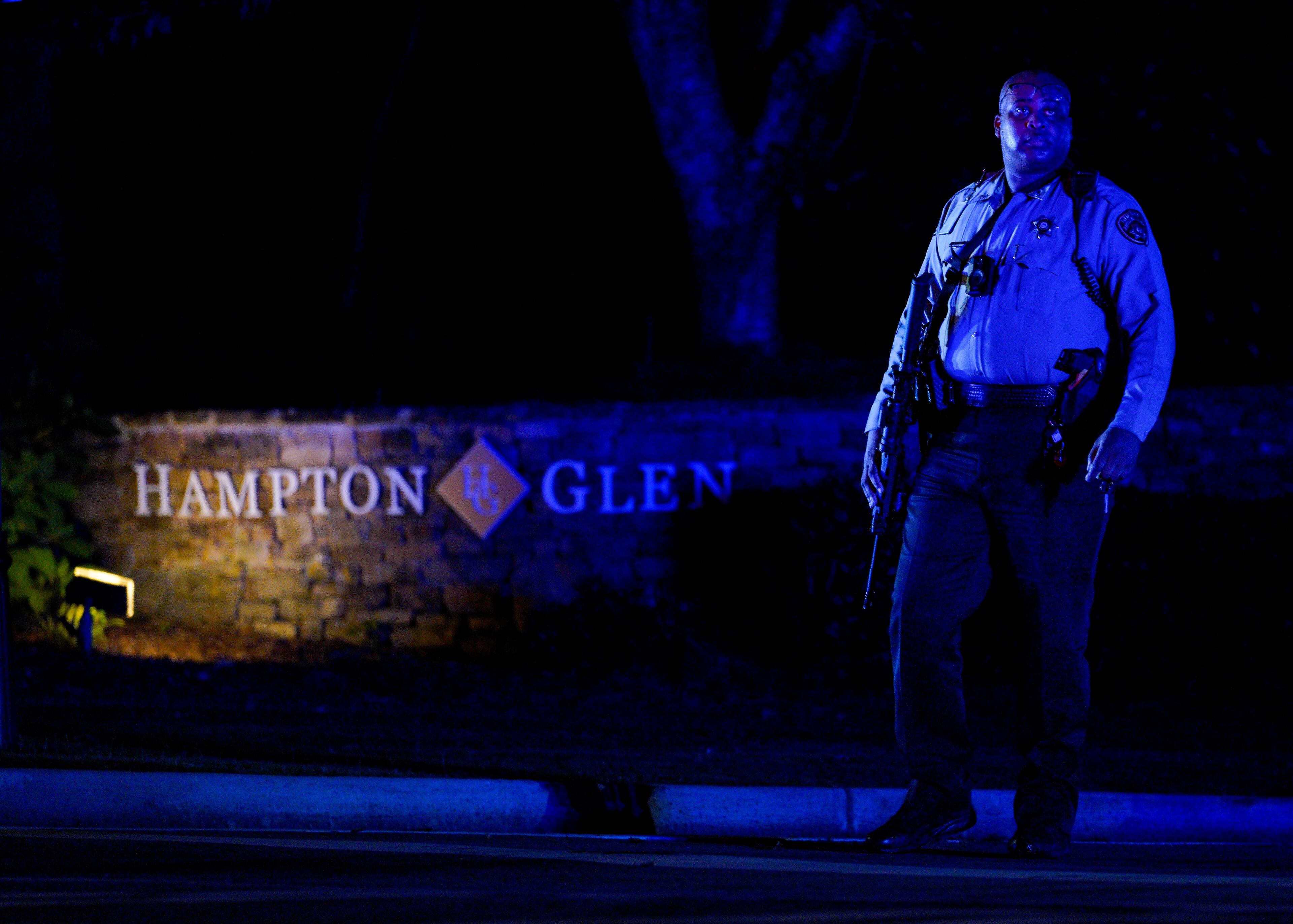 A Cobb County deputy walked around armed in front of the Hampton Glen subdivision off Irwin road after two deputies were killed Thursday evening serving a warrant. (Ben Hendren for The Atlanta Journal-Constitution)