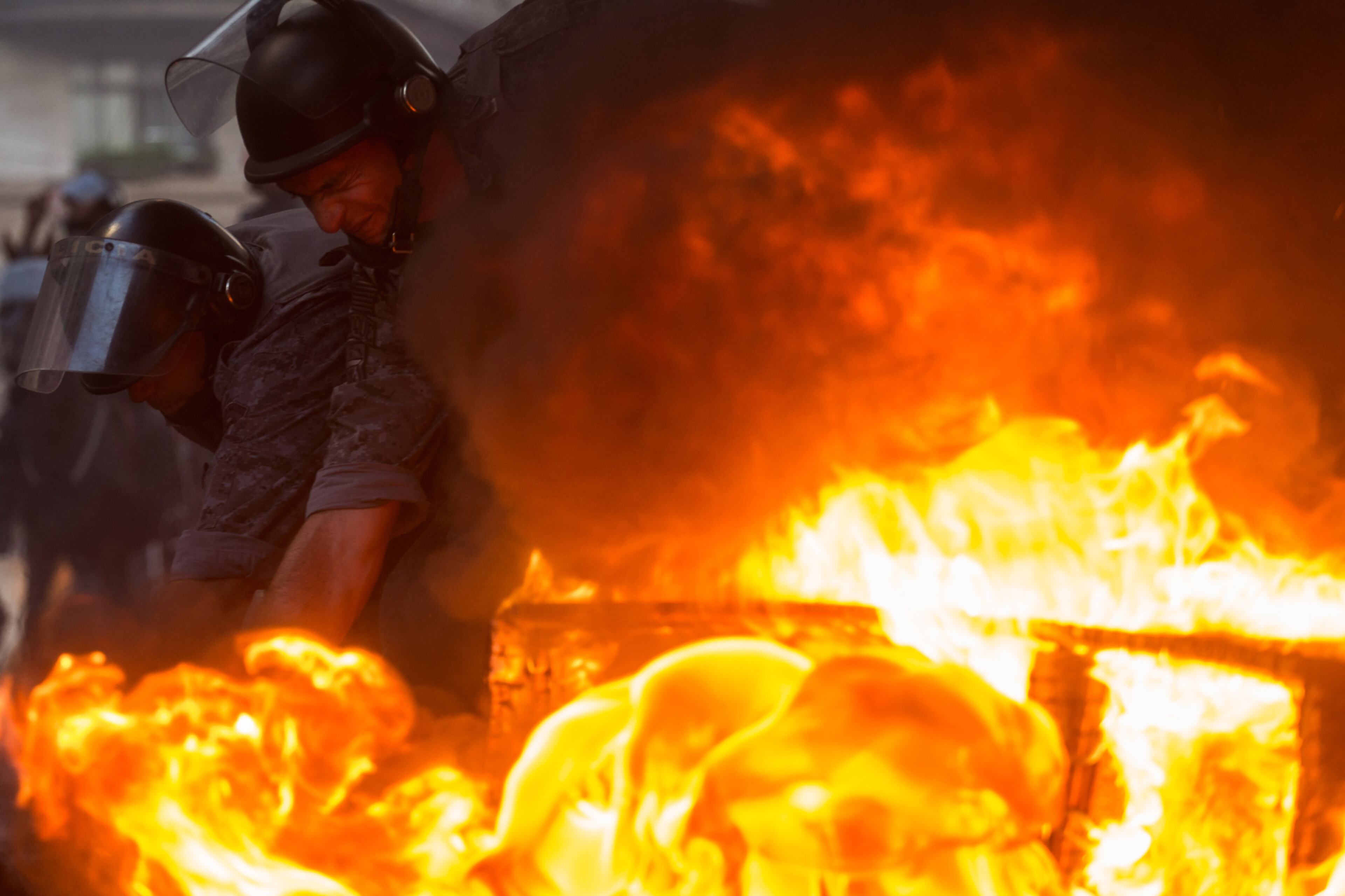 SAO PAULO, BRAZIL - JUNE 30: Police officers deal with a fire started by protesters linked to the social movements Front for Housing Struggle in protest against the Social Security and Labor Reforms proposed by President Michel Temer on June 30, 2017 in Sao Paulo, Brazil. Several protests have taken place in various Brazilian cities against President Michel Temer, who was accused of corruption by the Attorney General's Office this week. (Photo by Victor Moriyama/Getty Images) *** BESTPIX ***