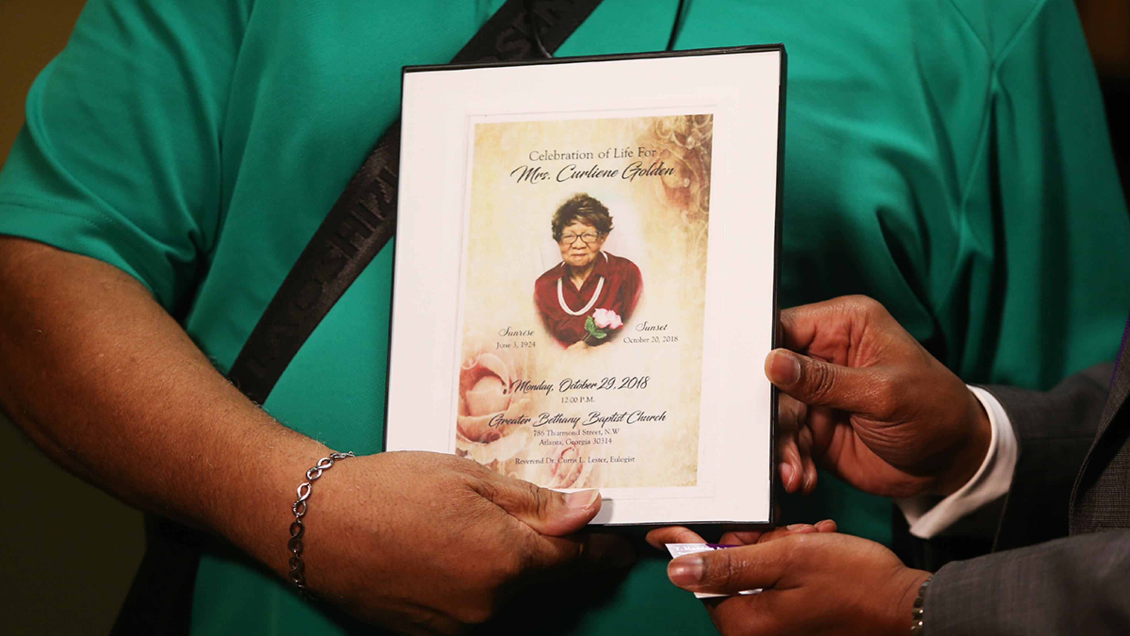 John Golden holds up the funeral program for his mother, Curliene Golden, at a press conference in July, in Jonesboro. He and his attorney suspect that she was sexually assaulted at Governor's Glen Assisted Living Facility in Clayton County. She died weeks later. (Christina Matacotta/Christina.Matacotta@ajc.com)