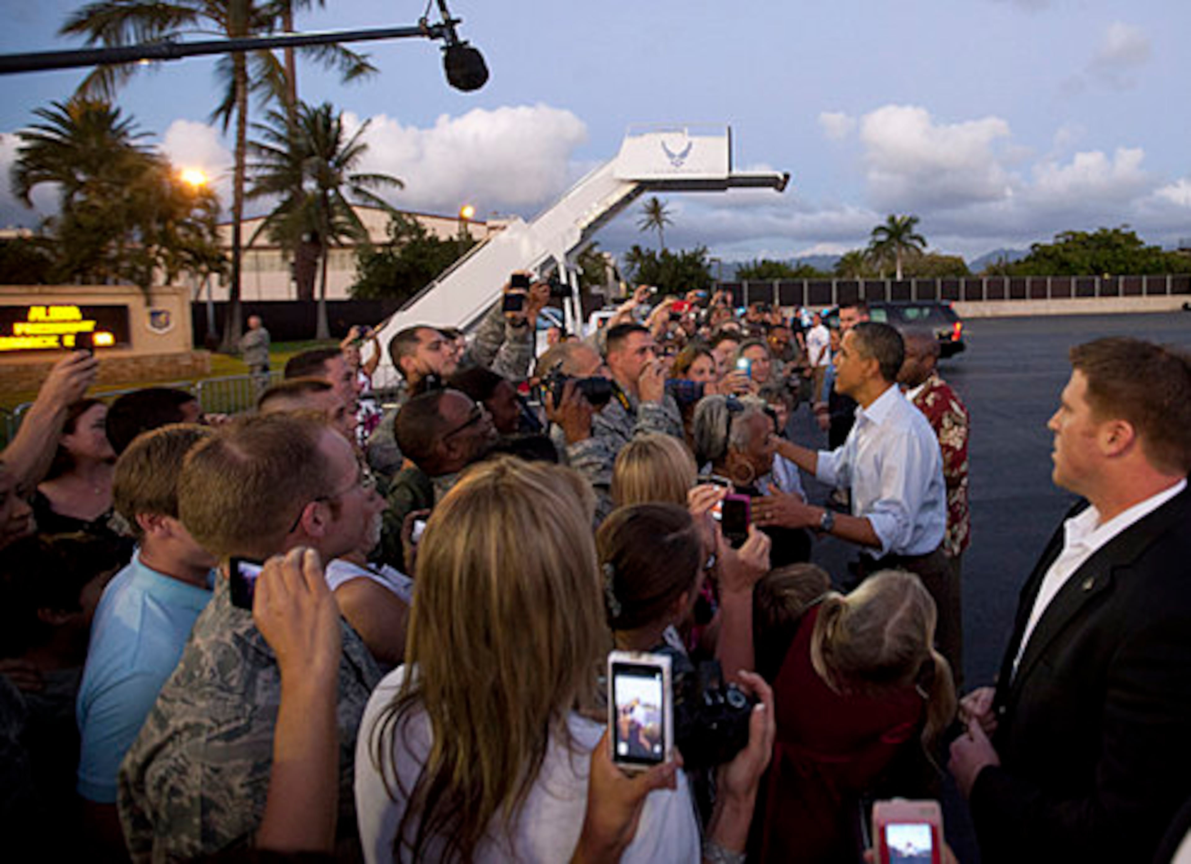 President Barack Obama shakes hands with people waiting to greet him on the tarmac as he steps off of Air Force One at Hickam Air Force Base in Friday, Dec. 23, 2011, in Honolulu.