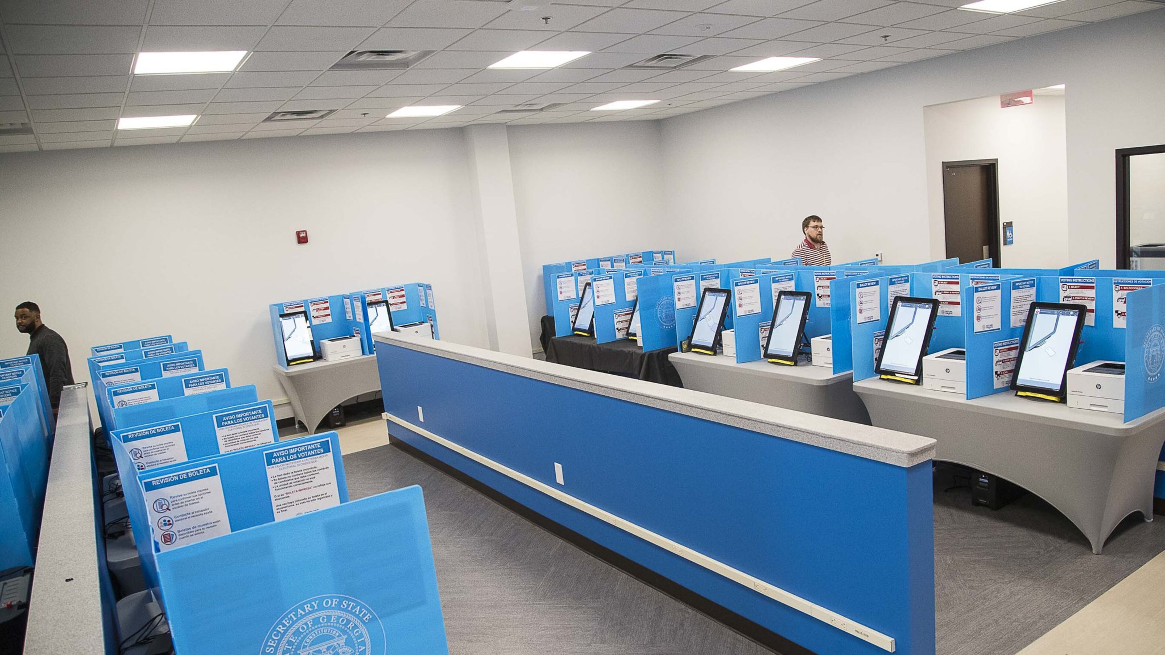 03/02/2020 — Lawrenceville, Georgia — Gwinnett County poll workers walk through the voting area at the Gwinnett County Voter Registrations and Elections office building during early voting for the presidential primary in Lawrenceville, Monday, March 2, 2020. (ALYSSA POINTER/ALYSSA.POINTER@AJC.COM)