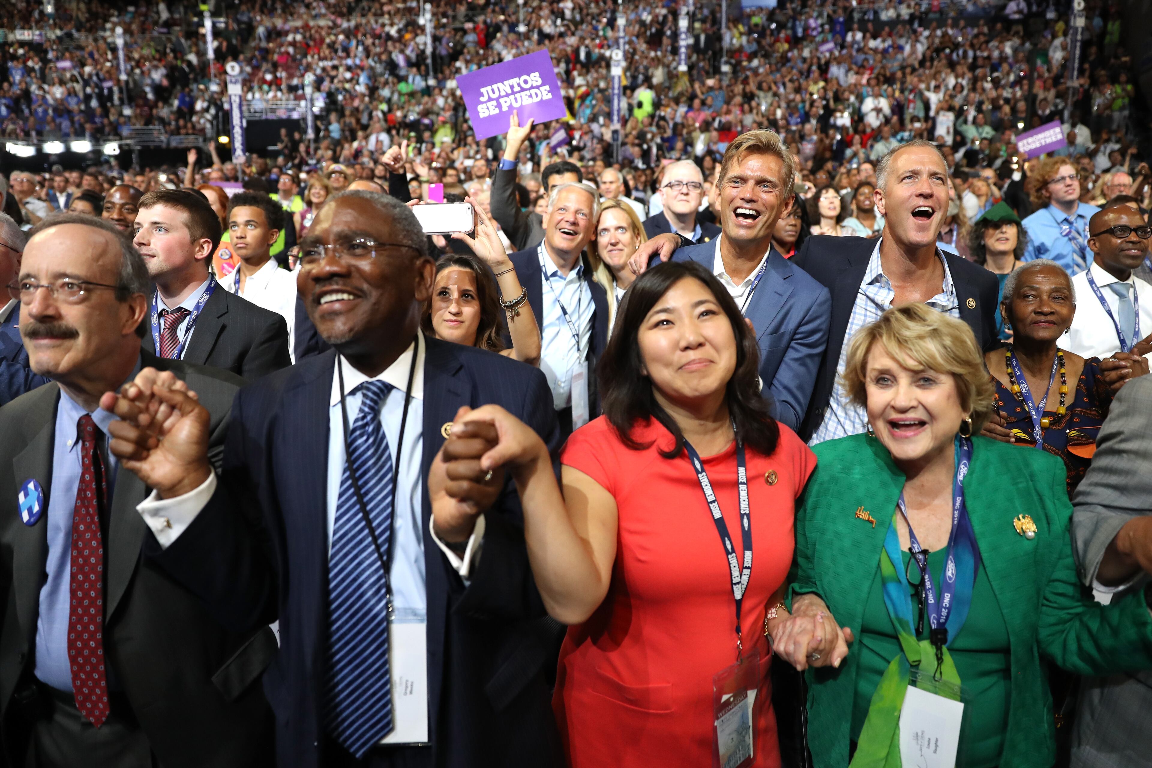 Delegates hold hands during the evening session of the third day of the Democratic National Convention at the Wells Fargo Center, July 27, 2016 in Philadelphia. (Photo by Joe Raedle/Getty Images)