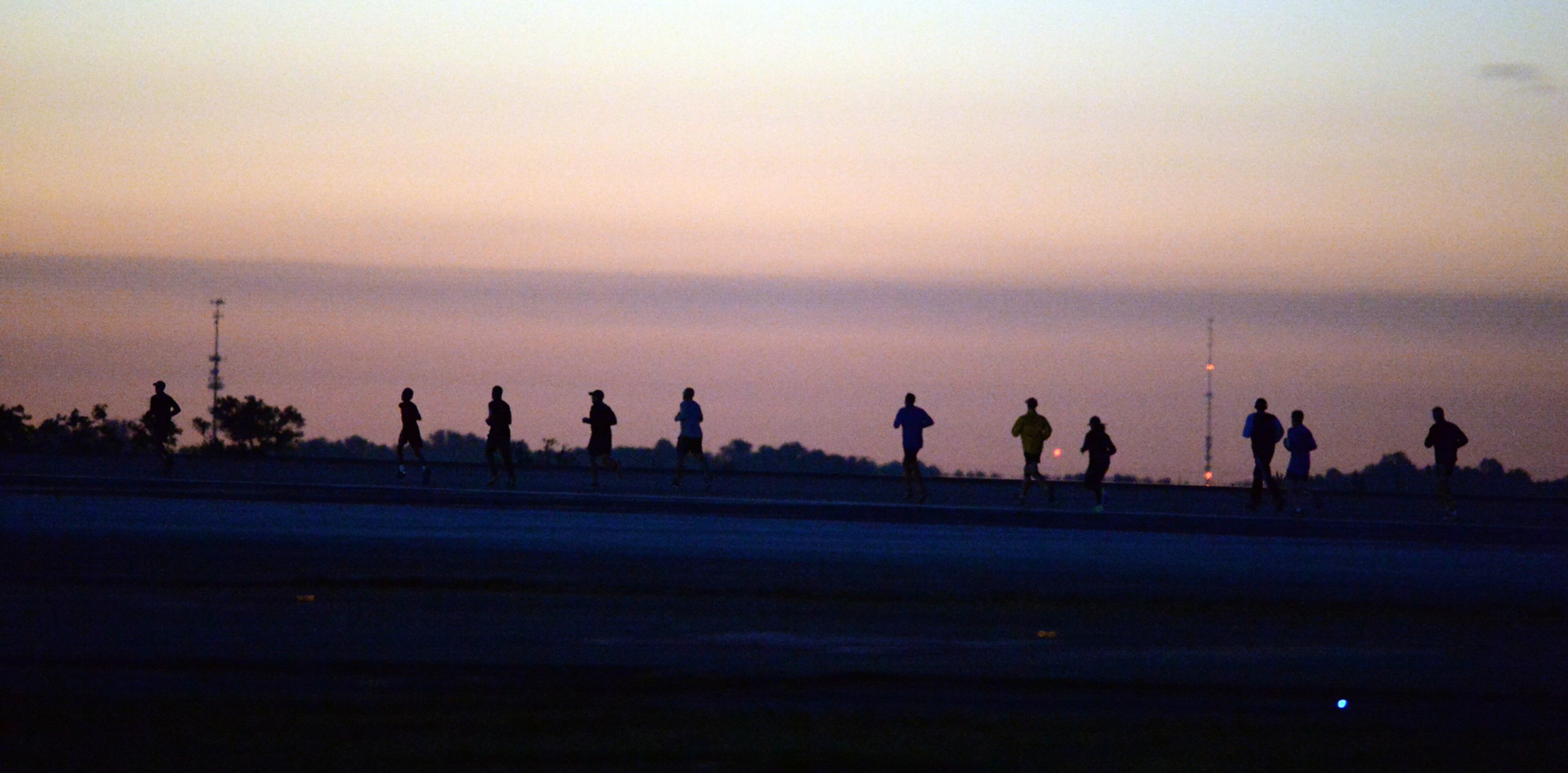 OCTOBER 17, 2015 ATLANTA Runners are silhouetted as the sun rises. Mayor Kasim Reed and United Way President Milton Little joined more than 2,000 runners at the Mayor’s Inaugural 5K on the 5th Runway at the world’s busiest airport Saturday, October 17, 2015. Airport officials shut down the 5th runway (Runway 10/28) until 8:15 am so runners and walkers could exit the course. All proceeds from the event will benefit United Way of Greater Atlanta. Major sponsors of The Mayor’s Inaugural 5K on the 5th Runway include Delta Air Lines, The Coca-Cola Company, Enterprise Rental Car, Georgia International Convention Center, MARTA, and Publix. Over $123,000 was raised, said airport spokesman Reese McCranie. The race's overall winner was Andrew Murfee, 15, a Woodward Academy student. KENT D. JOHNSON/KDJOHNSON@AJC.COM