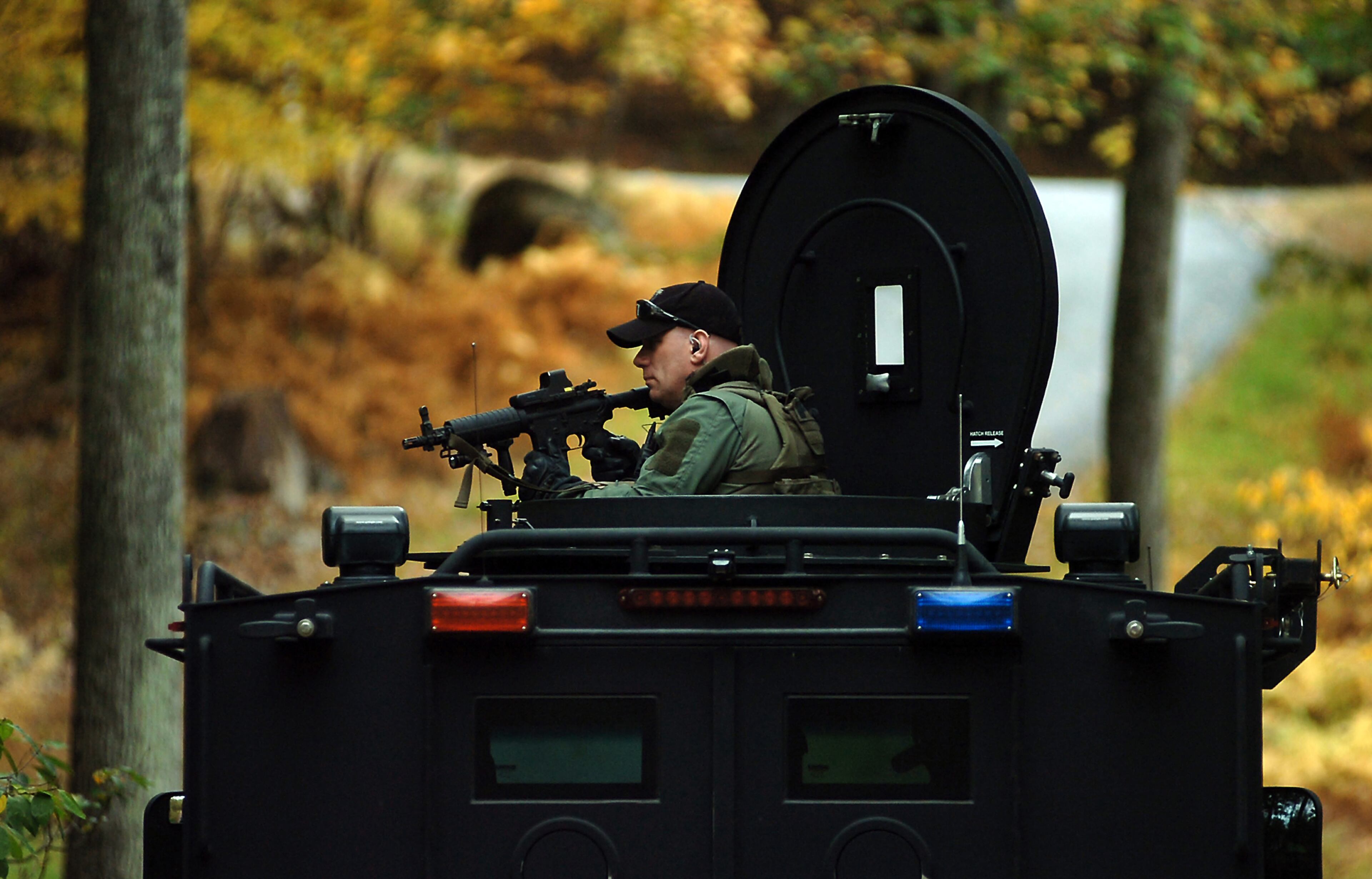 A member of the Scranton, Pa., Police Special Operations Group, is positioned in an armored vehicle Thursday, Oct. 2, 2014, in Barrett Township near Canadensis, Pa., as they search for suspected killer Eric Frein. A massive manhunt has been underway for 31-year-old Frein in the rugged terrain of the Pocono Mountains since Sept. 12. The self-taught survivalist is charged with killing Cpl. Bryon Dickson and seriously wounding Trooper Alex Douglass outside their barracks in Blooming Grove. (AP Photo/Scranton Times & Tribune, Butch Comegys) WILKES BARRE TIMES-LEADER OUT; MANDATORY CREDIT