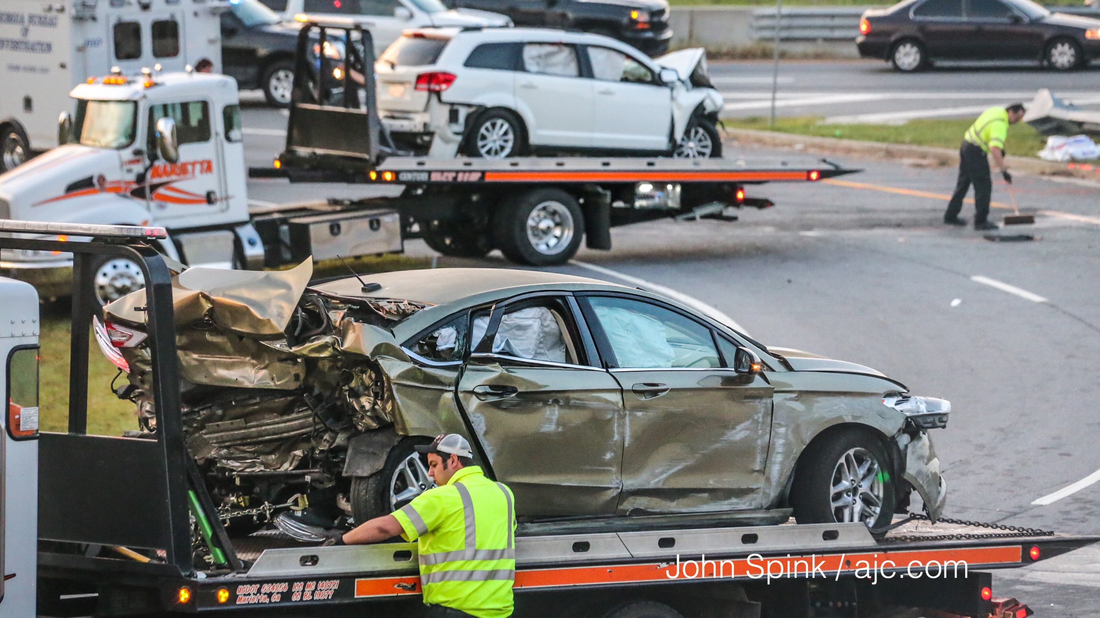 Cars are removed from the site of a crash Friday in Cobb County. JOHN SPINK / JSPINK@AJC.COM