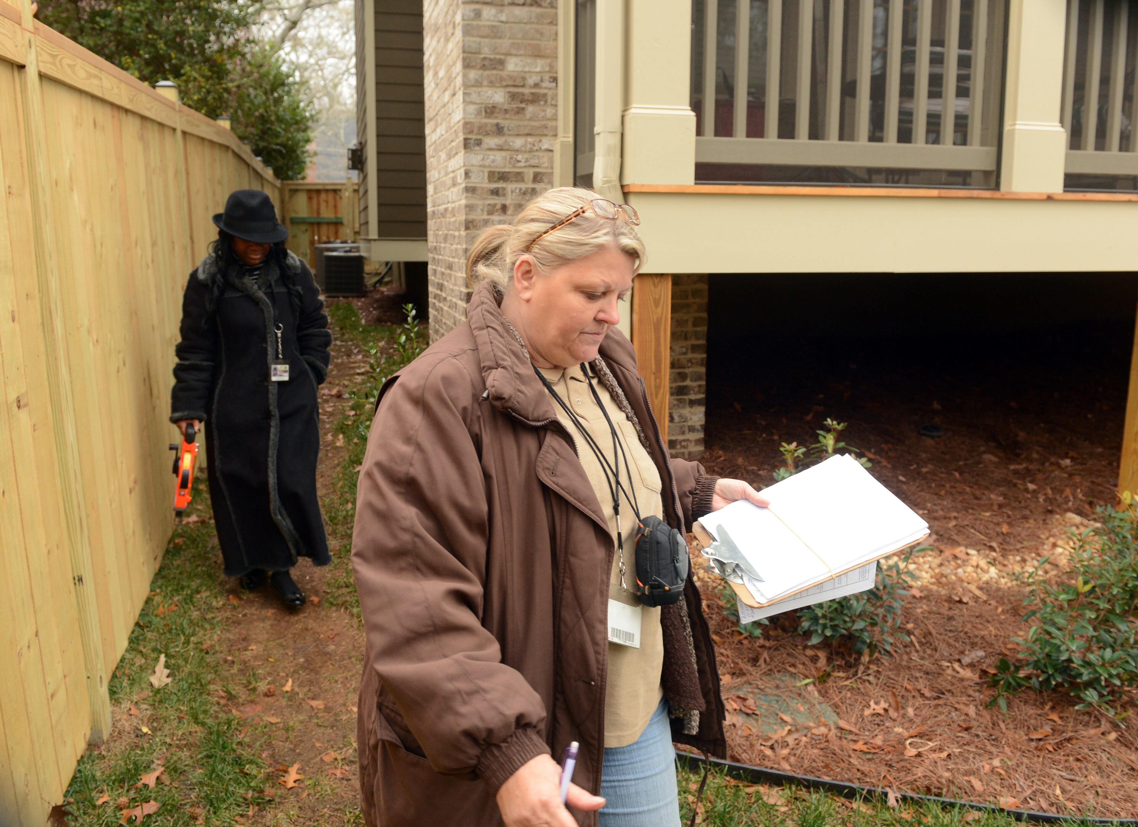 Property appraisers Joyce Lackey (brown coat) and Yvette Thomas evaluate a property on Avery Drive in Decatur Wednesday, December 12, 2012. With the creation of the City of Brookhaven, the county is facing about $25 million in lost property taxes, business fees and other taxes. At the same time, 70 of the 101 officers in the north precinct will no longer be needed to patrol Brookhaven streets. DeKalb CEO Burrell Ellis has until Saturday to unveil his recommended 2013 budget, though his recommendation is expected Friday. The proposal then heads to the County Commission, which will give final approval to a budget in February. KENT D. JOHNSON / KDJOHNSON@AJC.COM