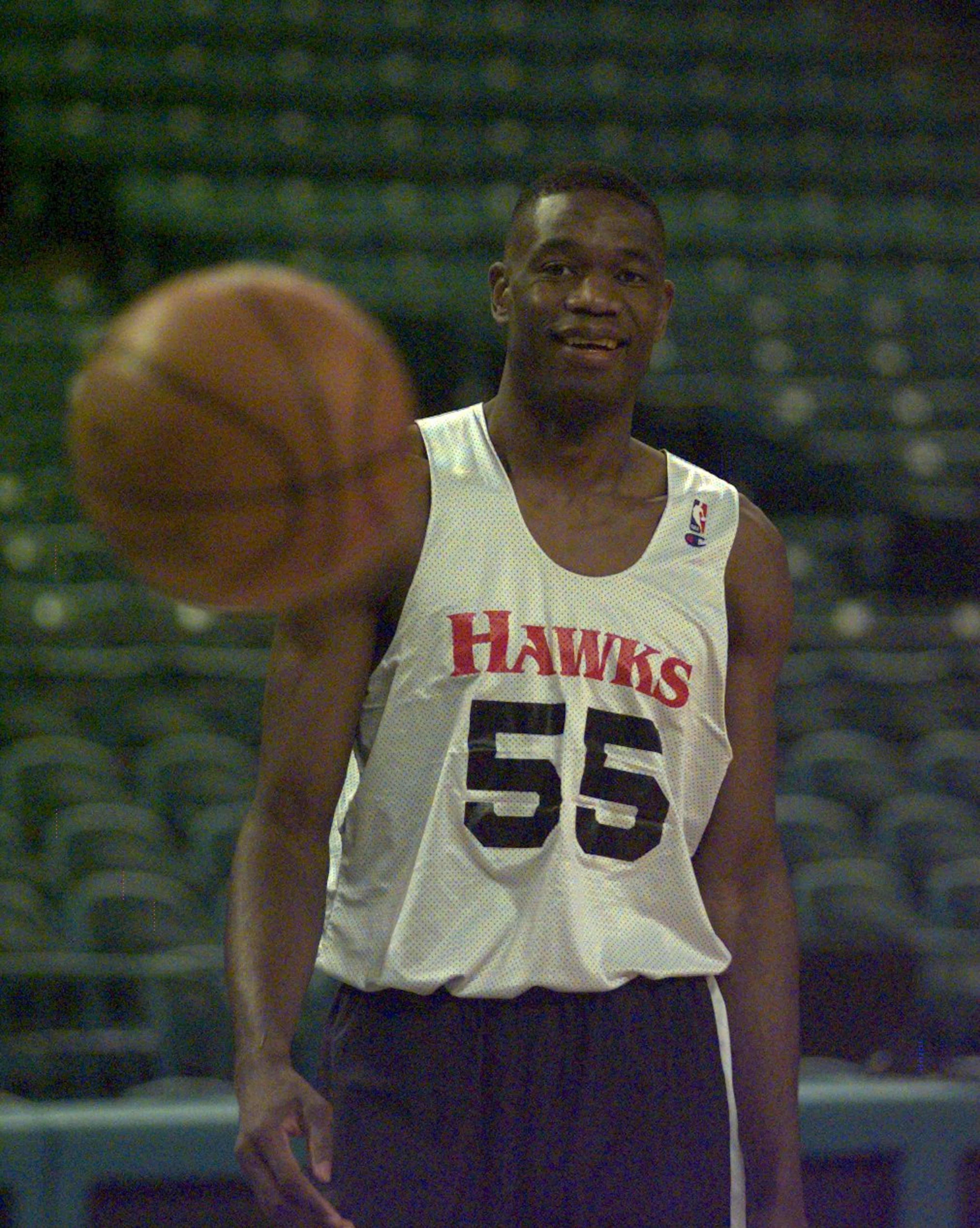 Atlanta Hawks' Dikembe Mutombo smiles while the ball bounces away in playoff round one practice at the Charlotte Coliseum Friday, April 24, 1998. (DAVID TULIS/AJC Staff)