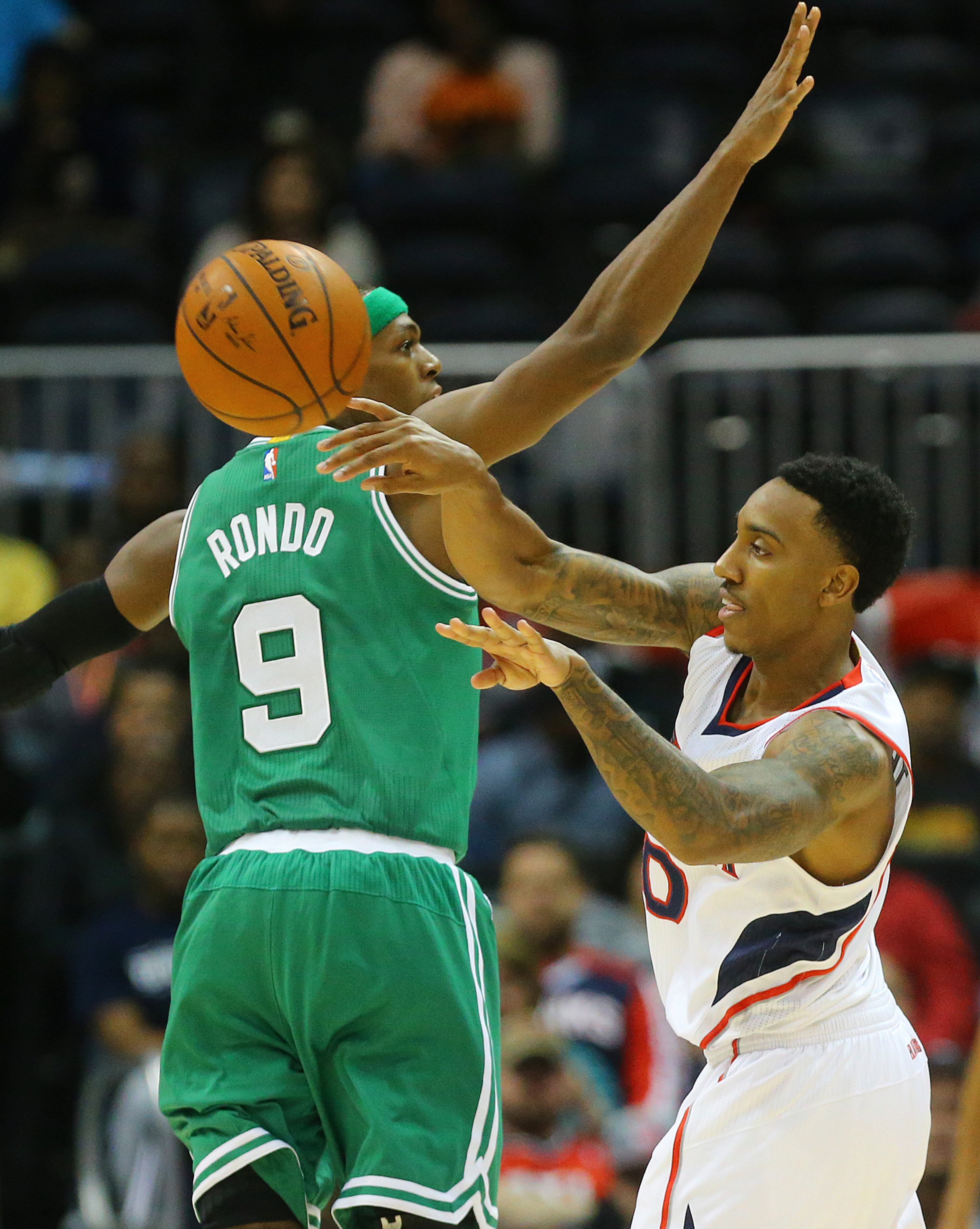 Hawks guard Jeff Teague gets off a pass under pressure from Celtics Rajon Rondo during the first half in an NBA basketball game on Tuesday, Dec. 2, 2014, in Atlanta. CURTIS COMPTON / CCOMPTON@AJC.COM