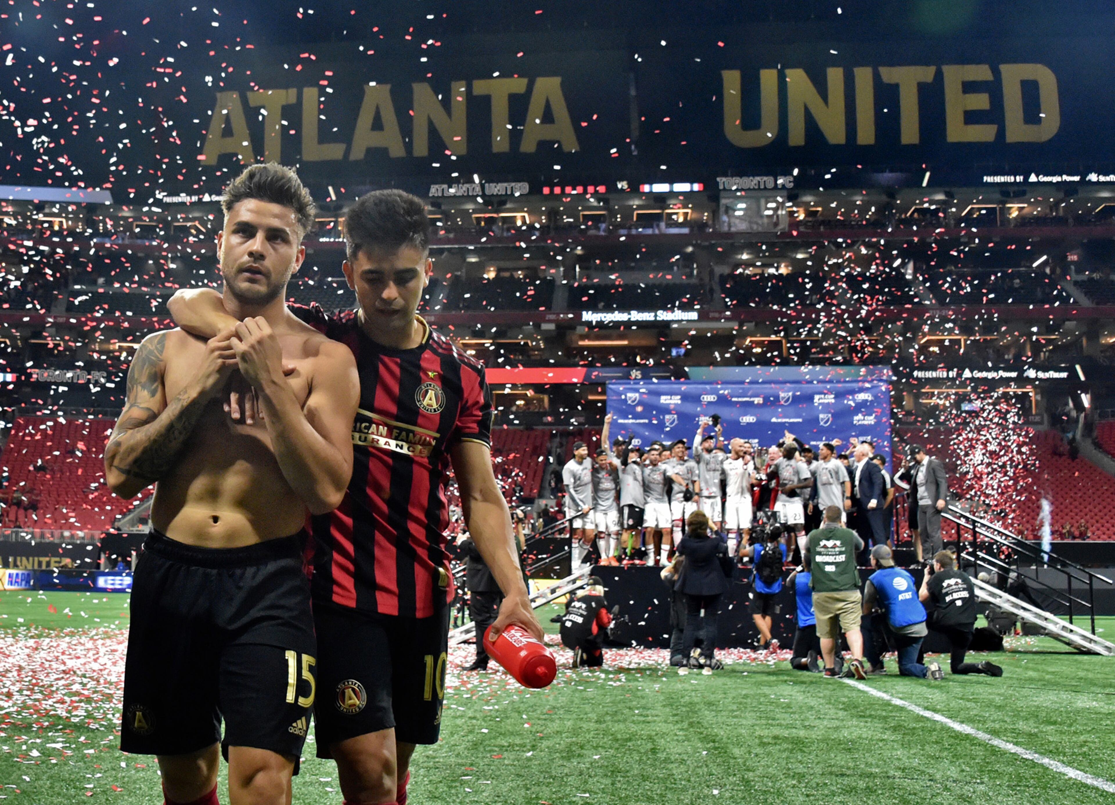 October 30, 2019 Atlanta - Atlanta United forward Hector Villalba (15) and Atlanta United midfielder Gonzalo Martinez (10) leave the field as Toronto FC players celebrate their victory during the Eastern Conference Final soccer match at Mercedes-Benz Stadium on Wednesday, October 30, 2019. (Hyosub Shin / Hyosub.Shin@ajc.com)