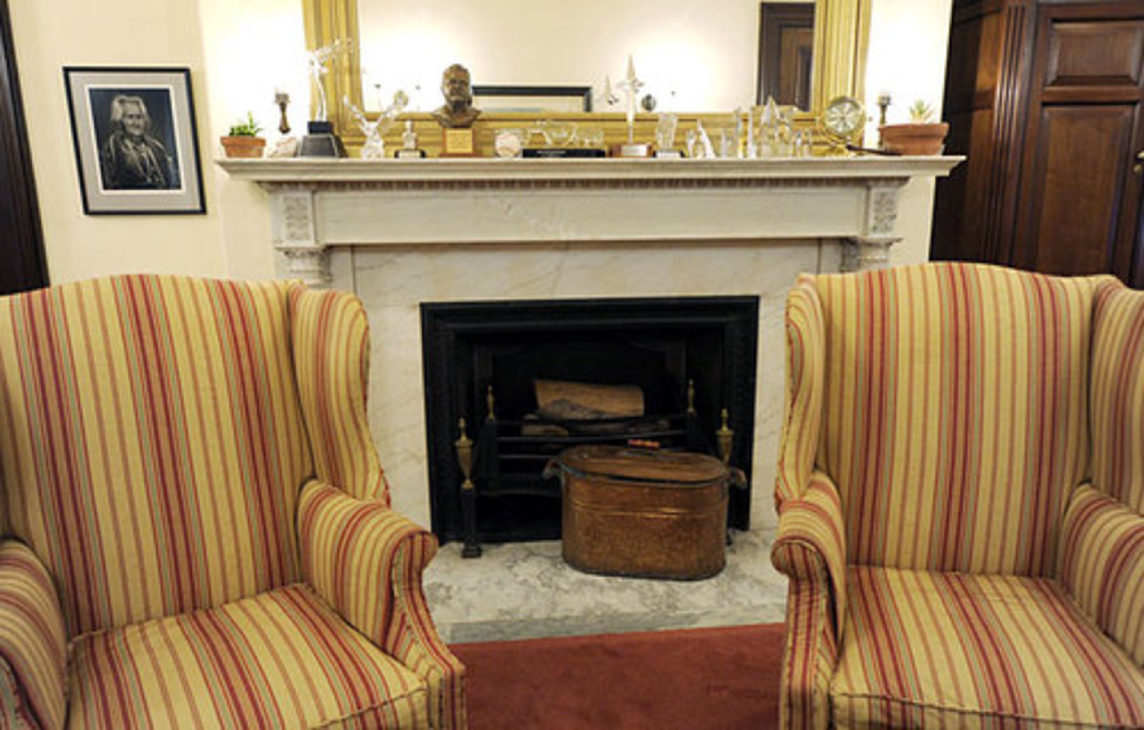 The mantel of McCain's marble fireplace is covered with various awards and a few tired-looking plants.