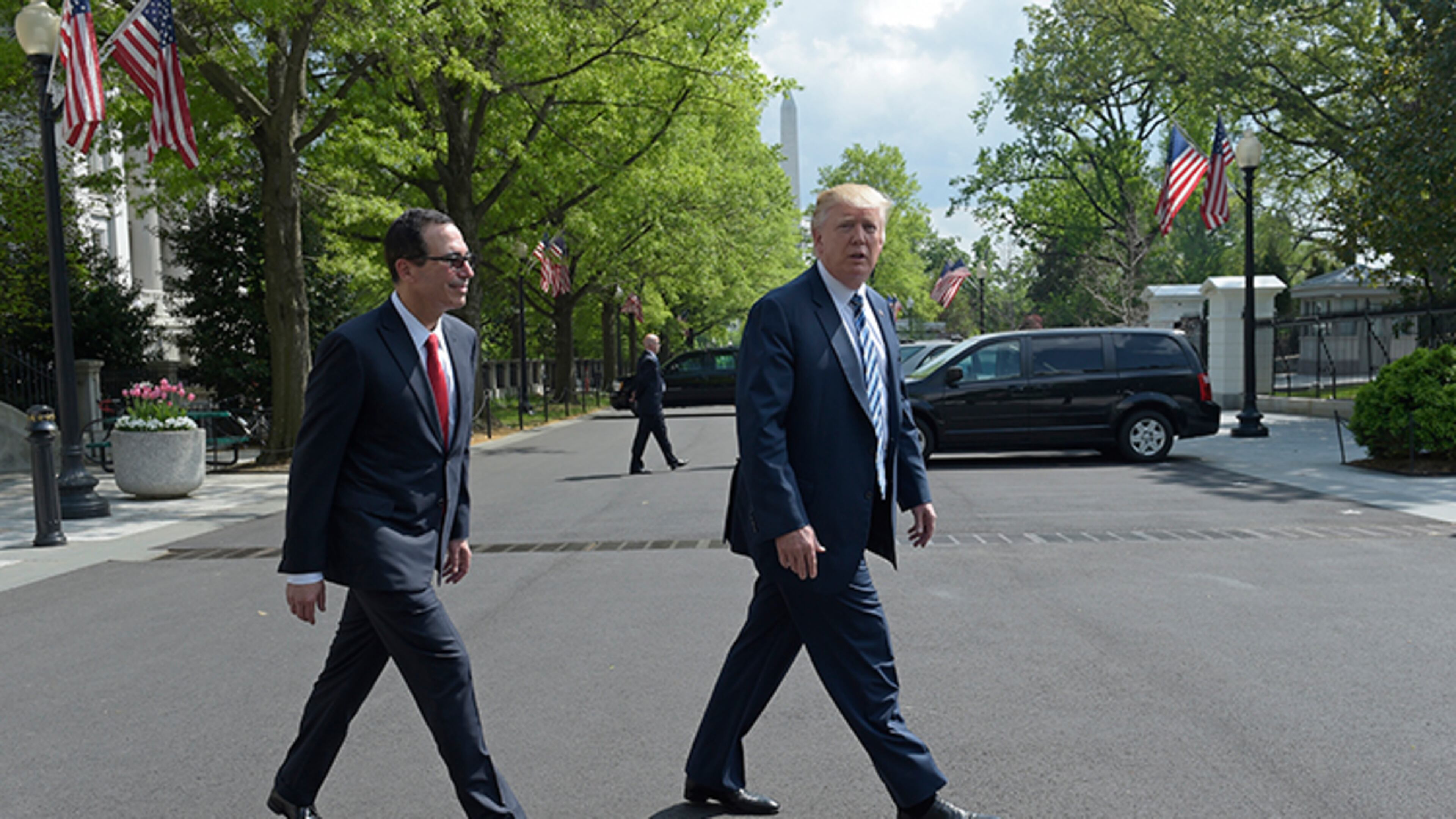President Donald Trump and Treasury Secretary Steven Mnuchin walk back to the White House in Washington, Friday, April 21, 2017, after the president signed an executive order to review tax regulations set last year by his predecessor, as well as two memos to potentially reconsider major elements of the 2010 Dodd-Frank financial reforms passed in the wake of the Great Recession, at the Treasury Department.