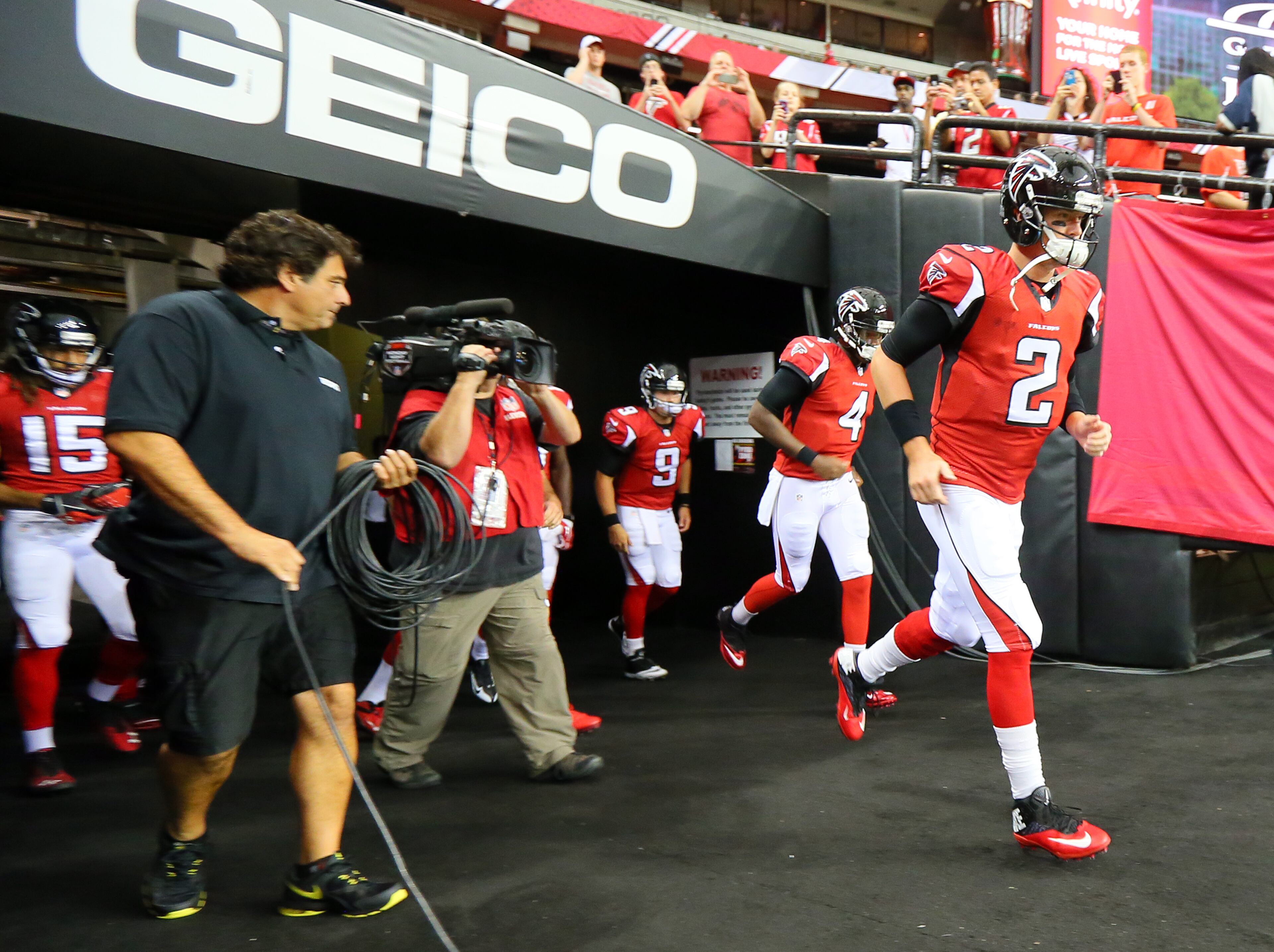Matt Ryan leads the Falcons out of the tunnel to warmup for their NFL exhibition game against the Cincinnati Bengals on Thursday, August 8, 2013, in Atlanta.