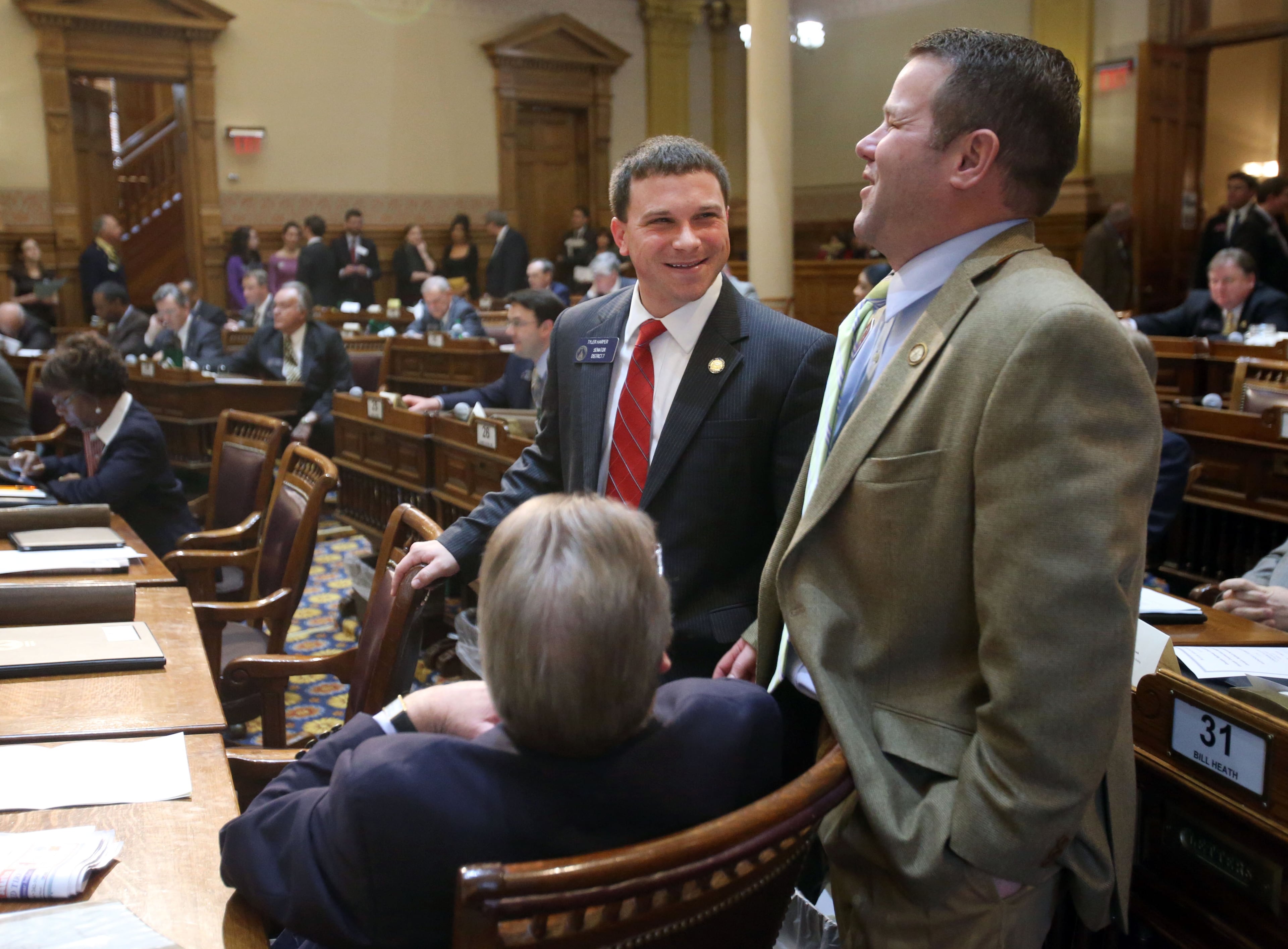 Freshman Sen. Tyler Harper, R-Ocilla, center, talks with Rep. Jay Roberts, R-Ocilla, right, and Sen. Tim Golden, R-Valdosta (sitting) after Sen. Harper was "hazed" during his first bill, Senate Bill 91, Wednesday, Feb. 13. Every time a freshman senator sponsors a first bill fellow senators "haze" them in the Senate chambers as a sort of rite of passage.
