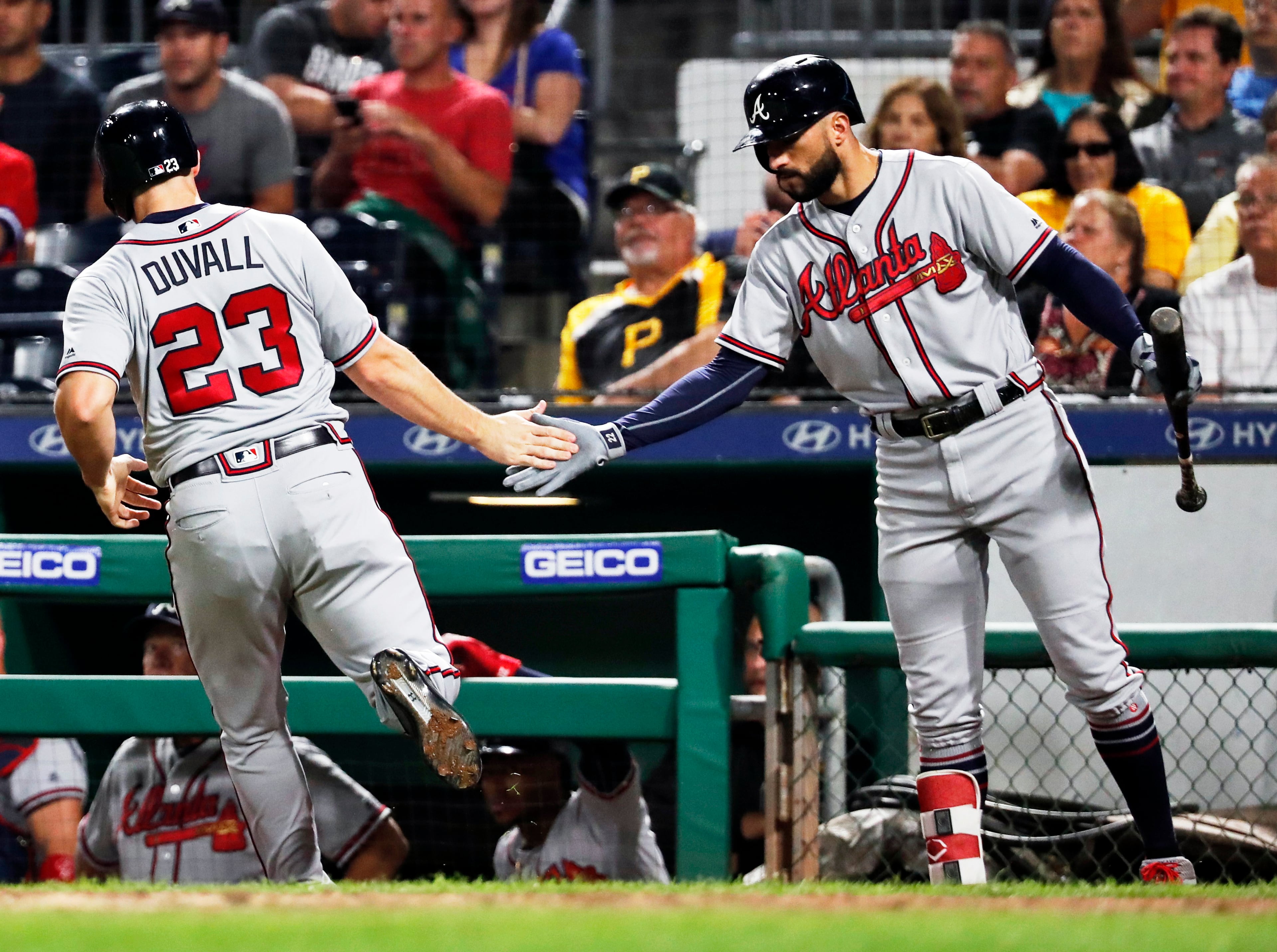 Atlanta Braves' Adam Duvall (23) is greeted by on-deck batter Nick Markakis after scoring from third on a sacrifice fly by Freddie Freeman during the ninth inning of a baseball game against the Pittsburgh Pirates on Wednesday, Aug. 22, 2018, in Pittsburgh. (AP Photo/Keith Srakocic)