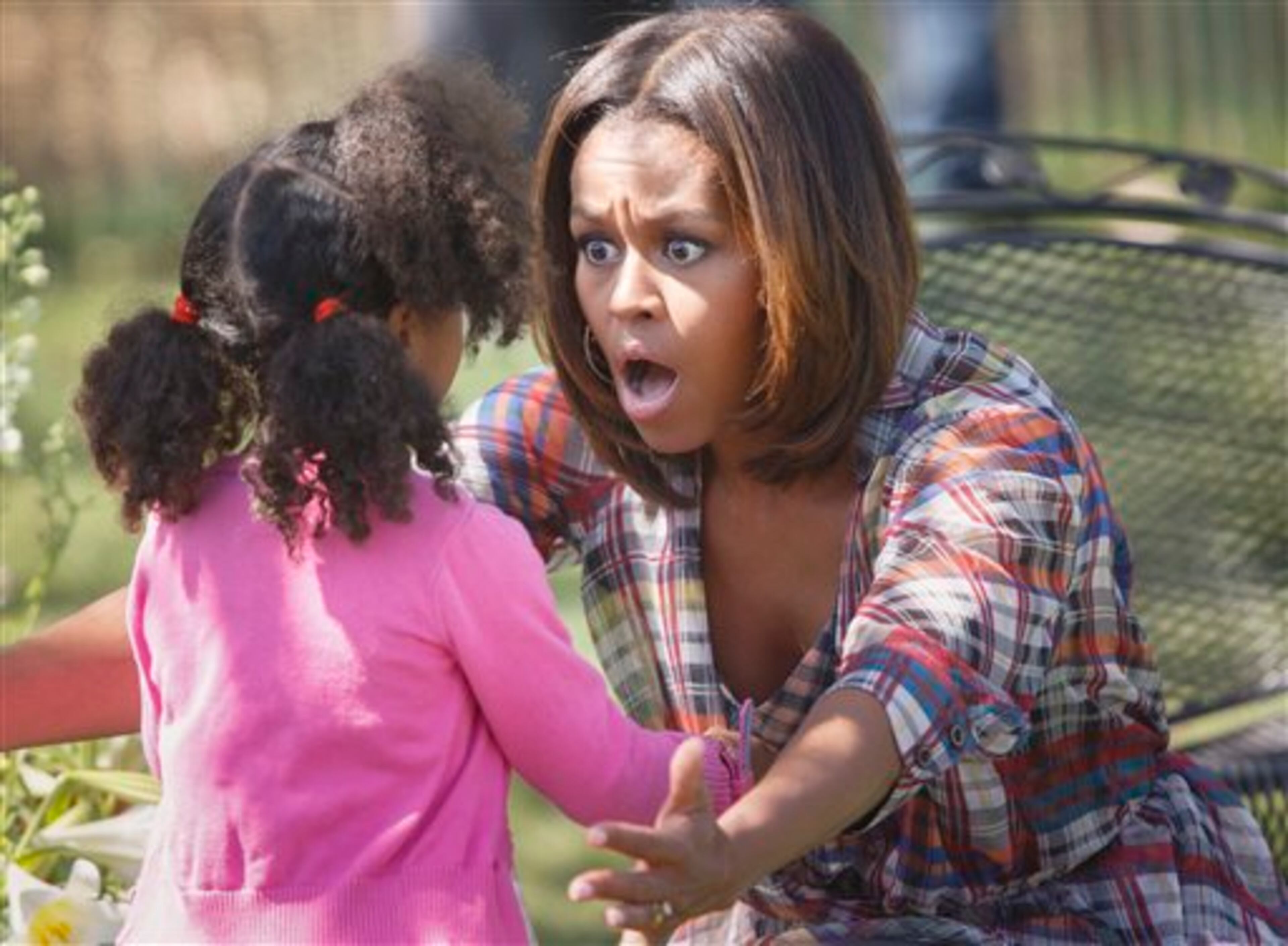 A youngster gets an enthusiastic hug from first lady Michelle Obama after she read to a group of children during the annual White House Easter Egg Roll, Monday, April 21, 2014, on the South Lawn of the White House in Washington. This year's event features live music, cooking stations, storytelling, and of course, some Easter egg rolling.(AP Photo/J. Scott Applewhite)
