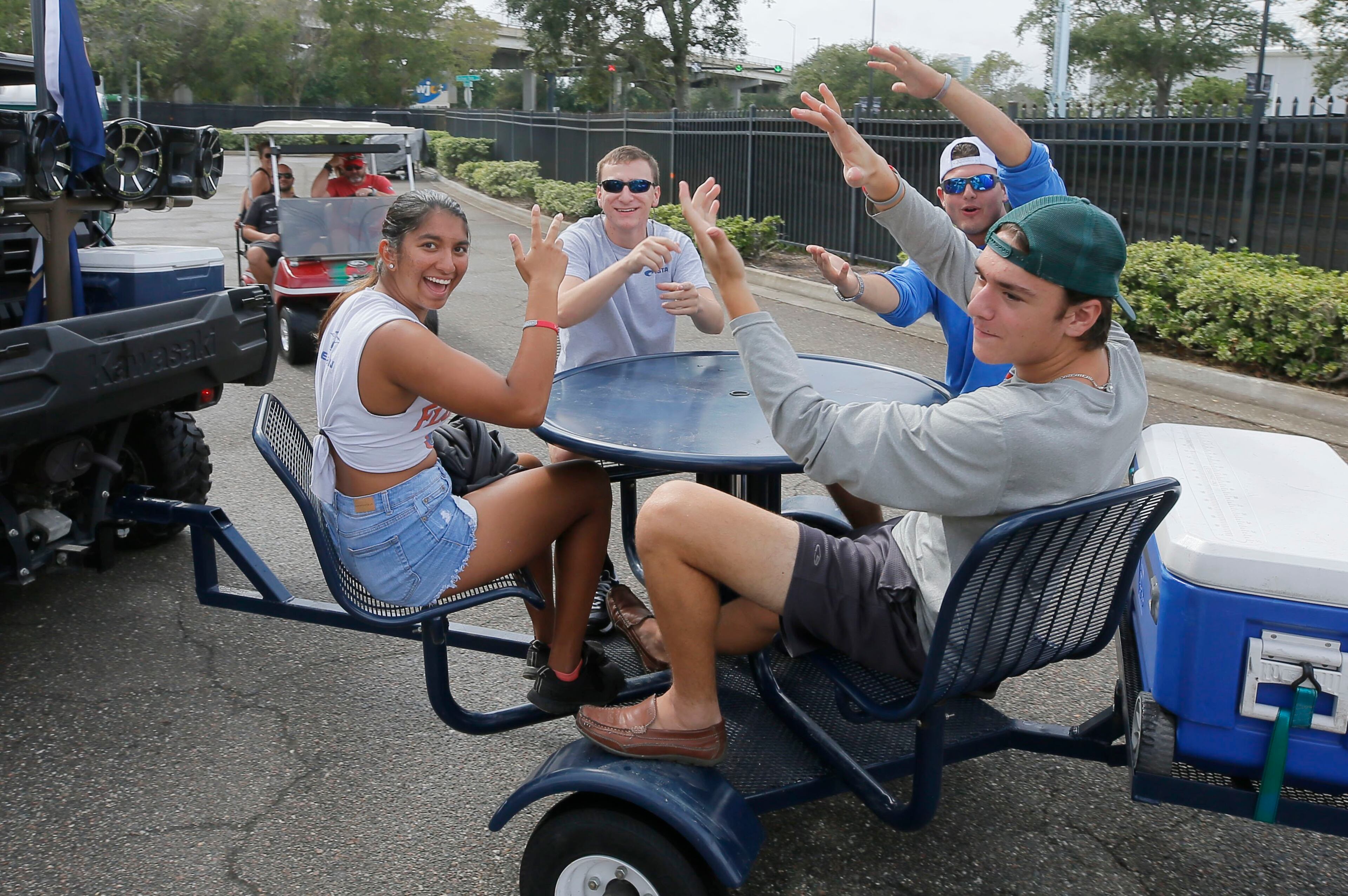 Gator fans do the Gator Chomp on a mobile bar table. (Bob Andres/bandres@ajc.com)