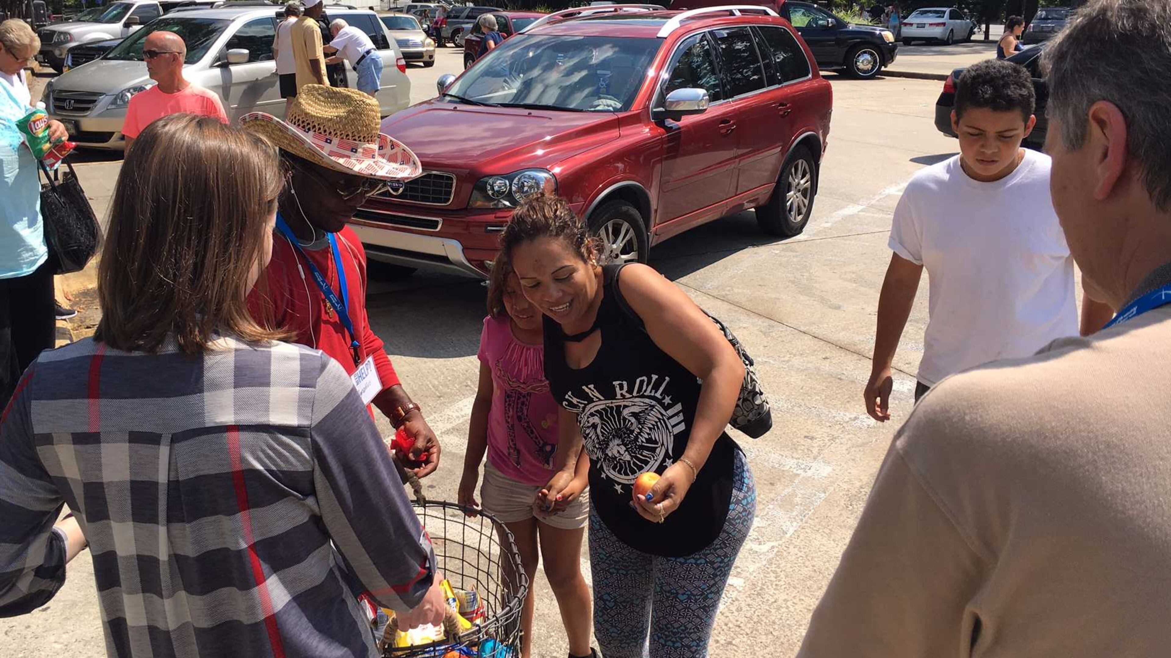 Luis Perez, in the white shirt, and his mother take snacks and drinks given out by a Macon church at a Bibb County rest stop Friday, Sept. 8, 2017. Perez, 15, said 10 of his family members drove in two cars from Homestead, Florida, to escape Hurricane Irma.