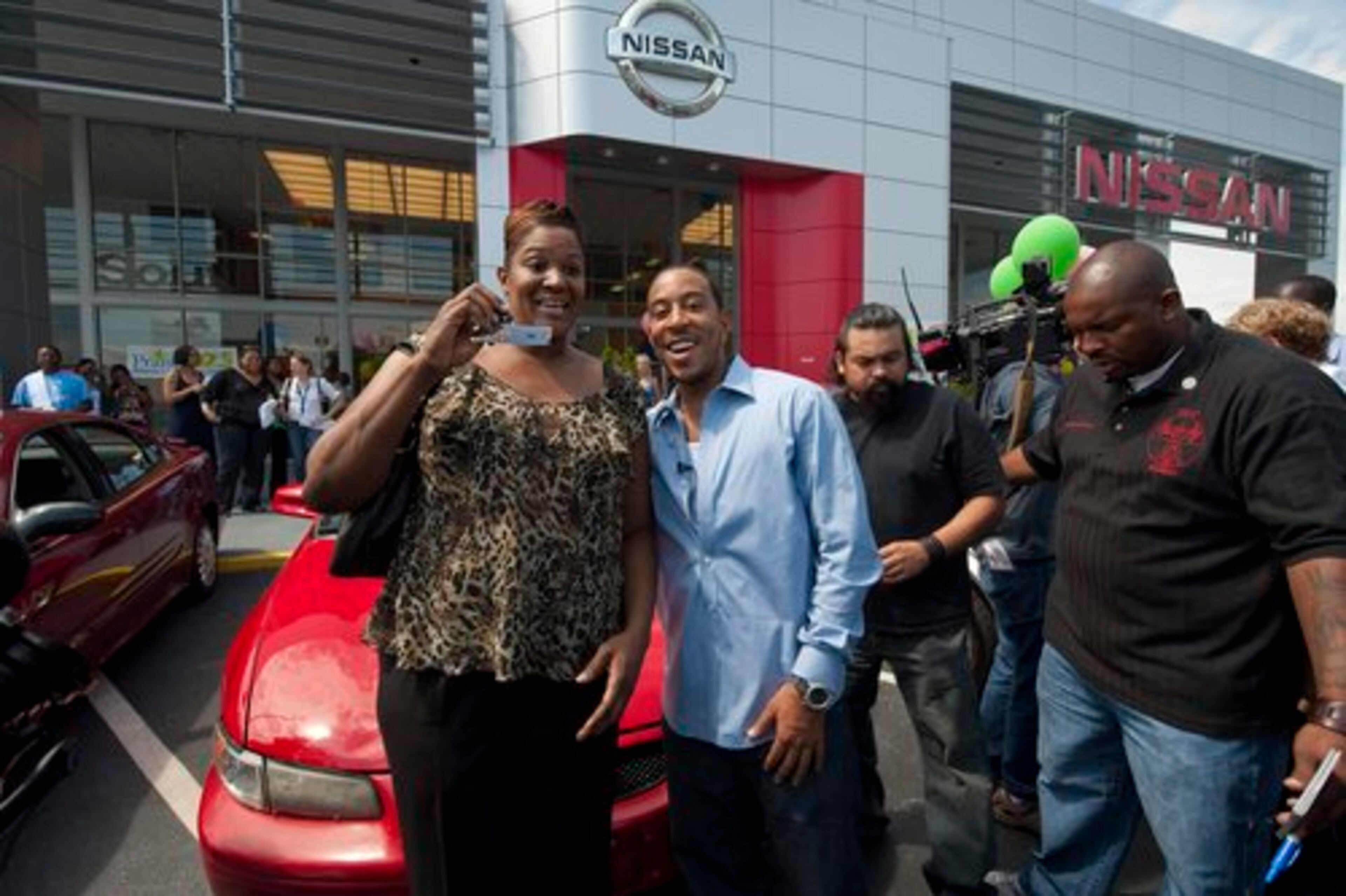 Ludacris, born Chris Bridges, and winner Pamela Lockett pose in front her car. Each of the used vehicles included free gas for 30 days. Winners were responsible for tags, registration, tax and insurance.