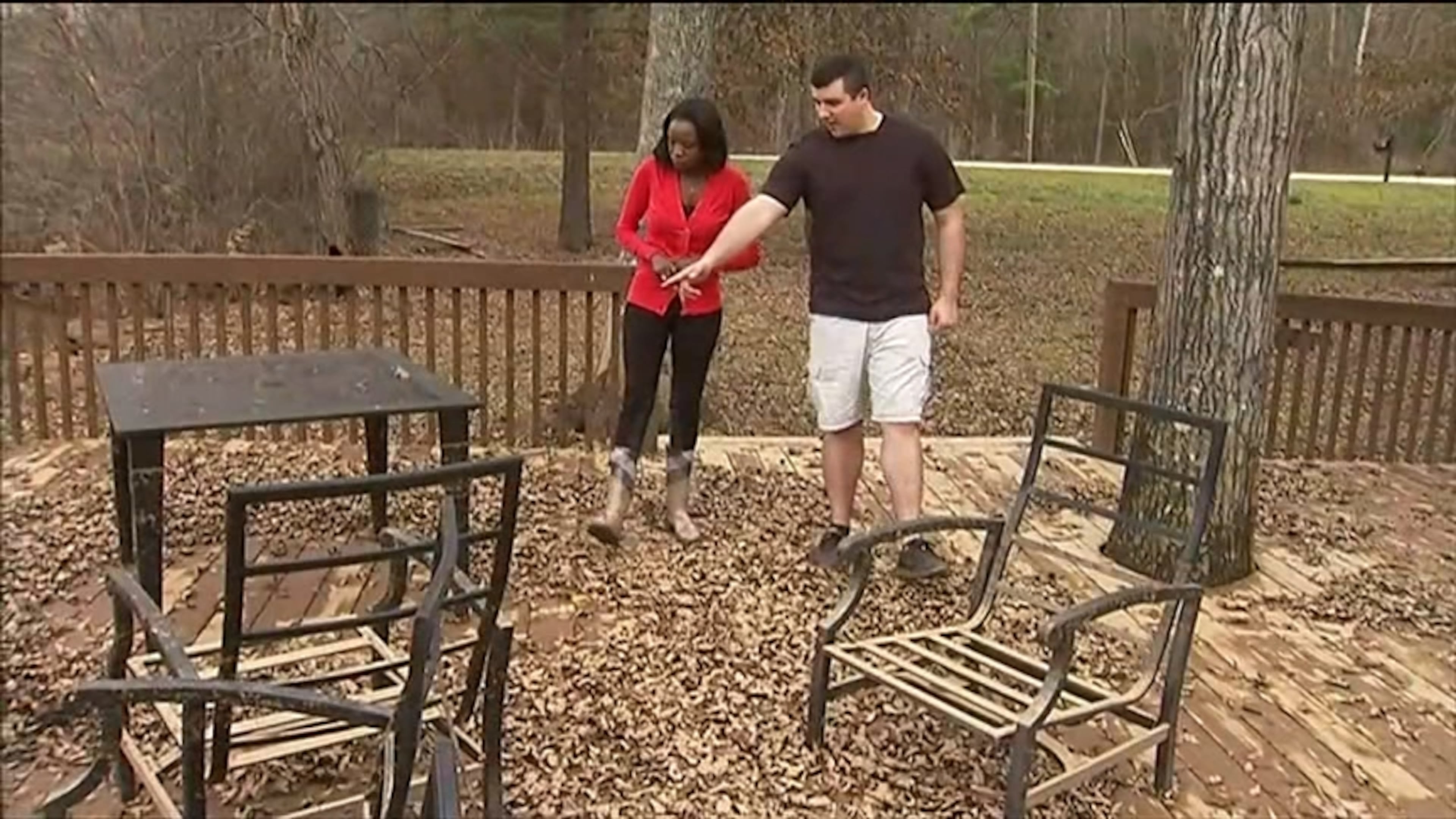 Nathan Bradley (right) shows Channel 2’s Audrey Washington the patio furniture covered in mud and other debris from flooding in 2020. (Courtesy of Channel 2 Action News)