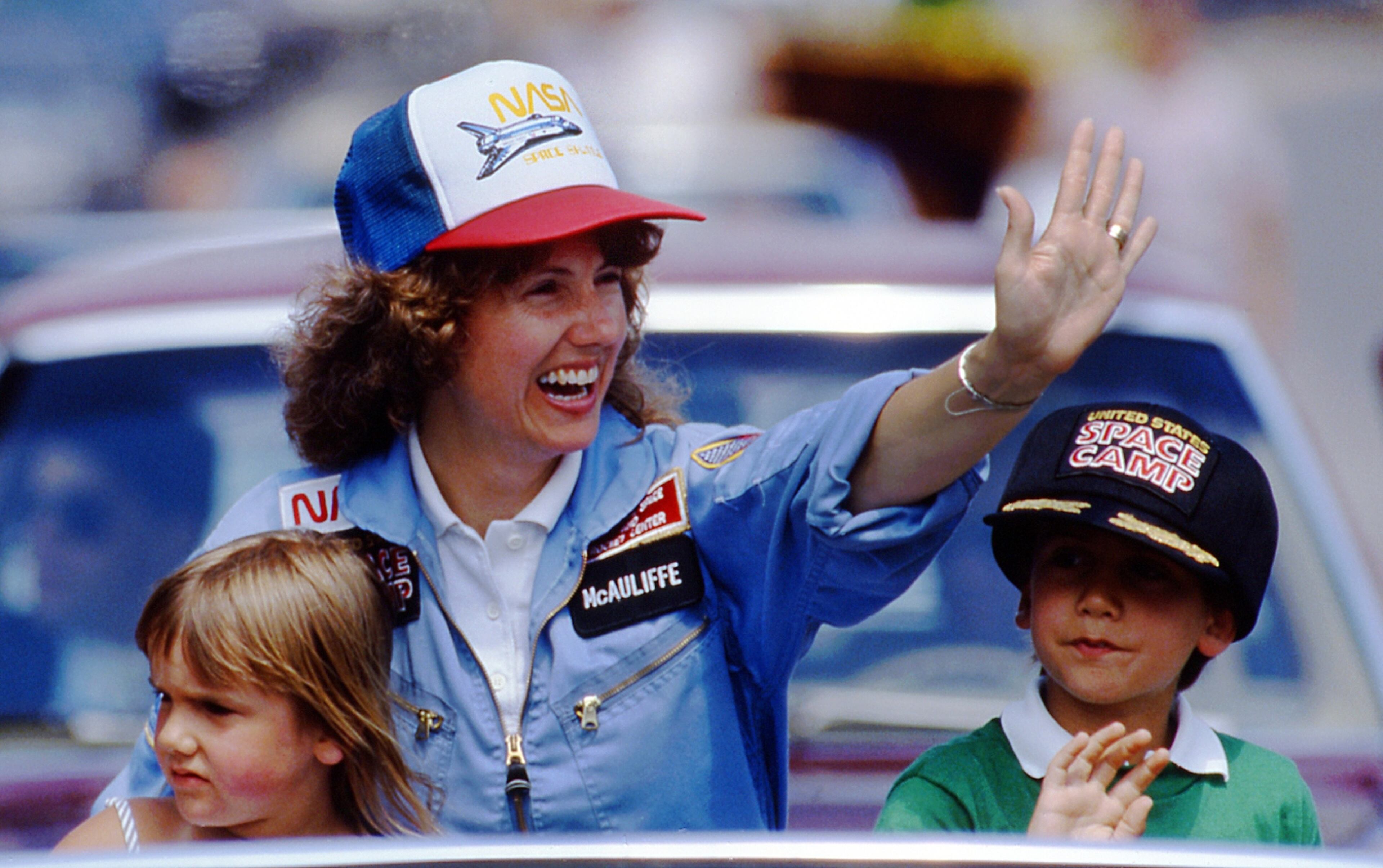 In this 1985 photo, high school teacher Christa McAuliffe rides with her children Caroline, left, and Scott during a parade down Main Street in Concord, N.H. McAuliffe was one of seven crew members killed in the Space Shuttle Challenger explosion on Jan. 28, 1986. (AP Photo/Jim Cole)
