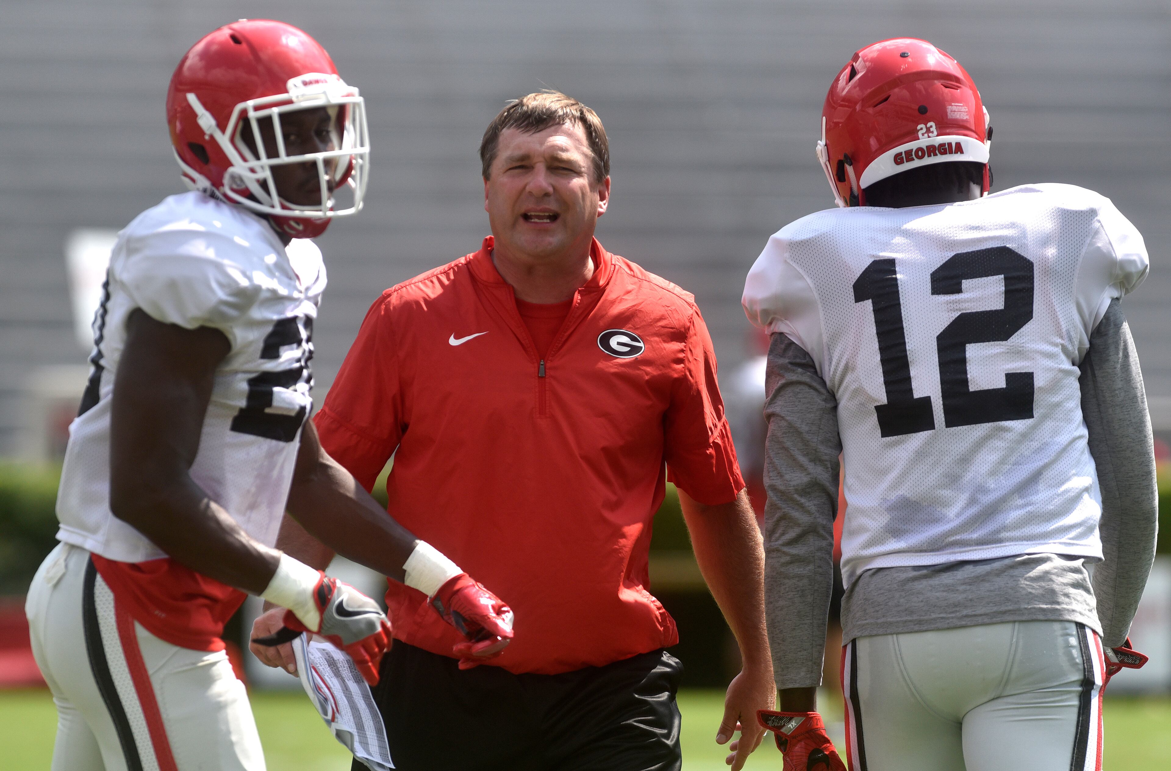 Georgia head coach Kirby Smart speaks with Georgia defensive back J.R. Reed (20) and Georgia defensive back Detravion Bishop (12) during an open practice during the annual UGA Fan Day at Sanford Stadium on Saturday, Aug 5, 2017 in Athens, Ga.
(RICHARD HAMM)