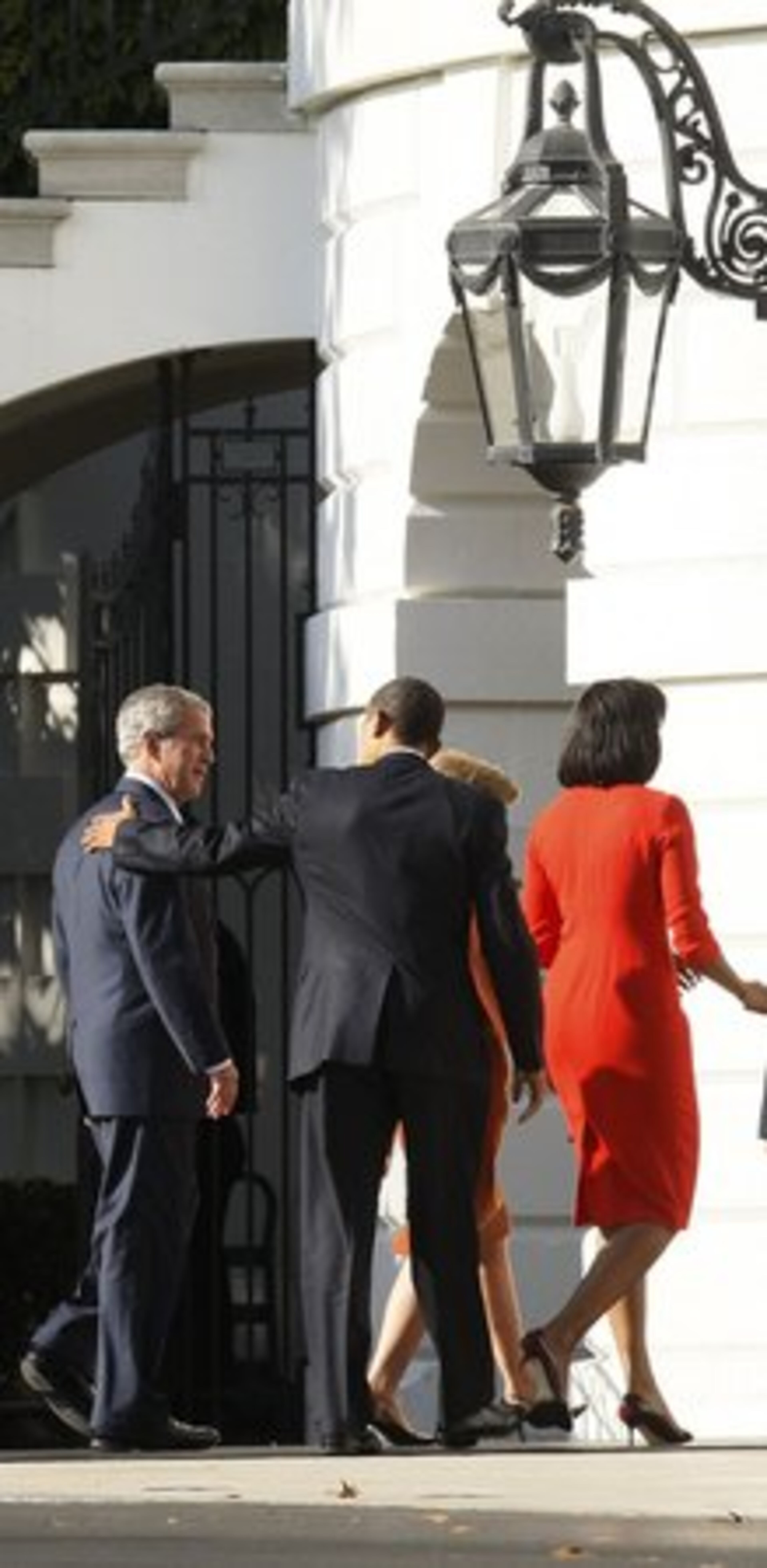 President-elect Obama puts his hand on President Bush's shoulder as he and his wife Michelle are welcomed to the White House by the president and first lady Laura Bush.