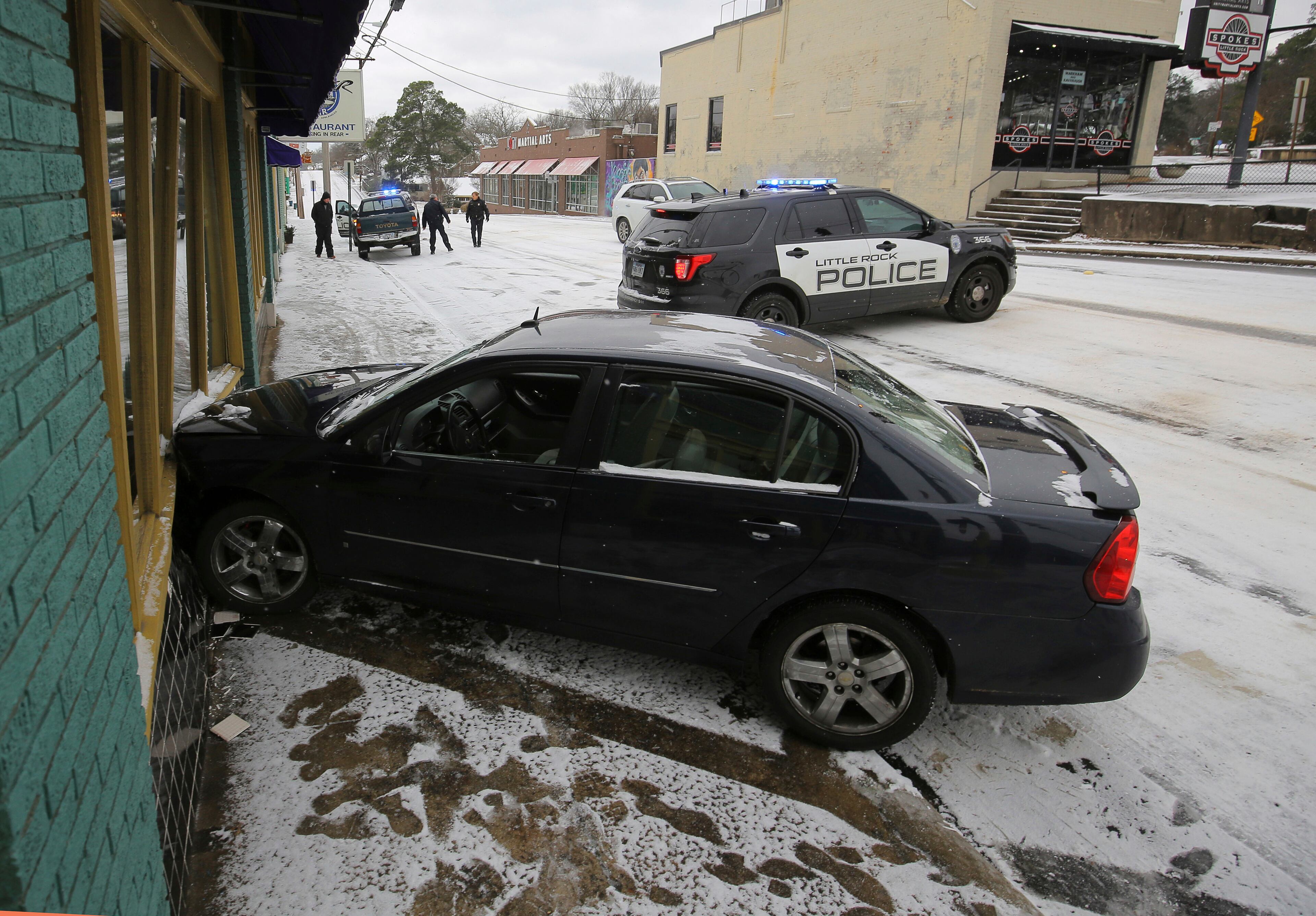 Little Rock police work the scene of an accident where a car struck the Oyster Bar restaurant along an icy W. Markham Street Friday morning, Jan. 6, 2017 in Little Rock.. (Stephen B. Thornton/The Arkansas Democrat-Gazette via AP)