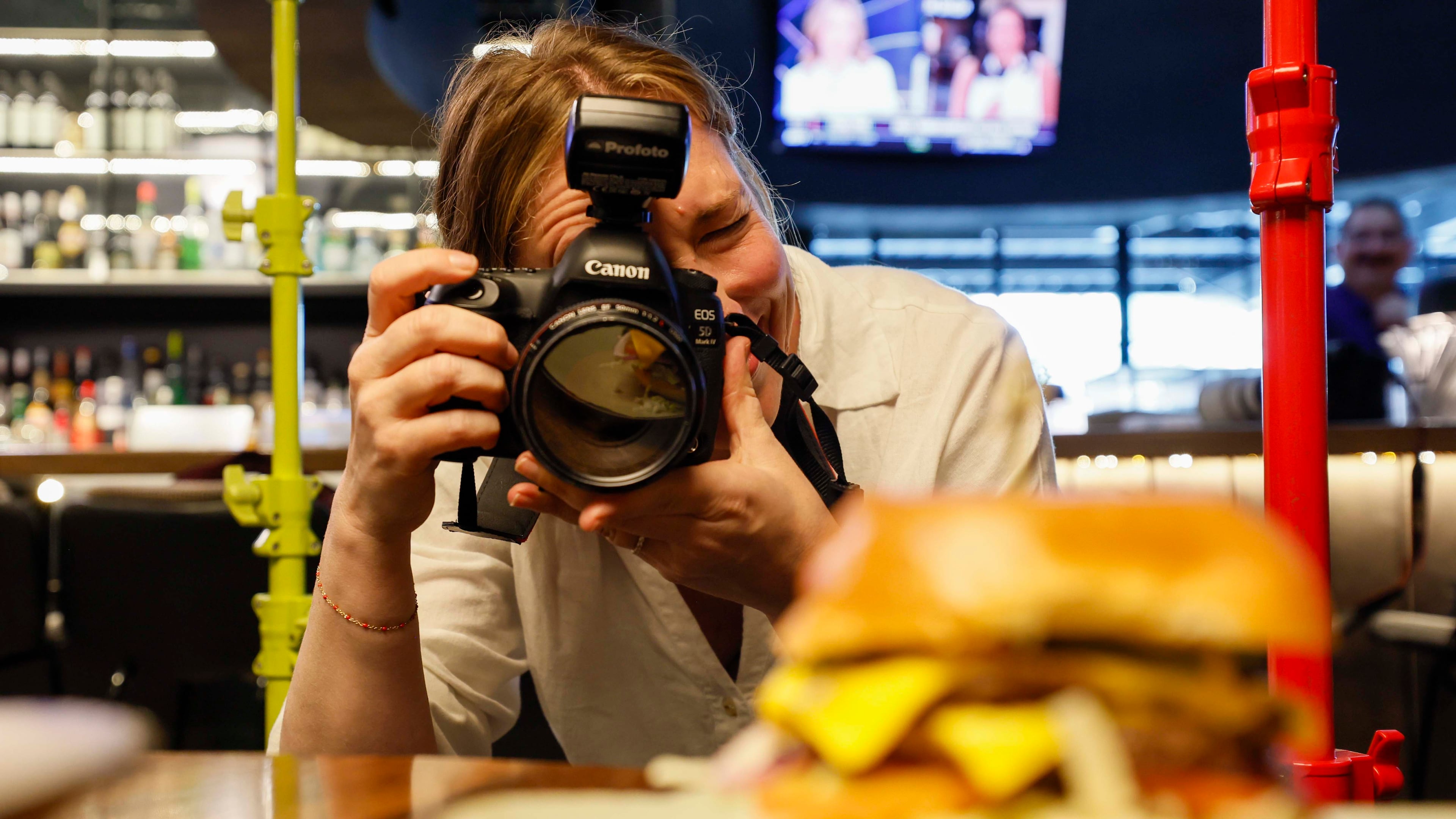 Atlanta-based lifestyle photographer Heidi Harris at work at the Painted Pickle, where she's using her own product: colorful light stands from her new company, Surrounded by Light. (Miguel Martinez/AJC)