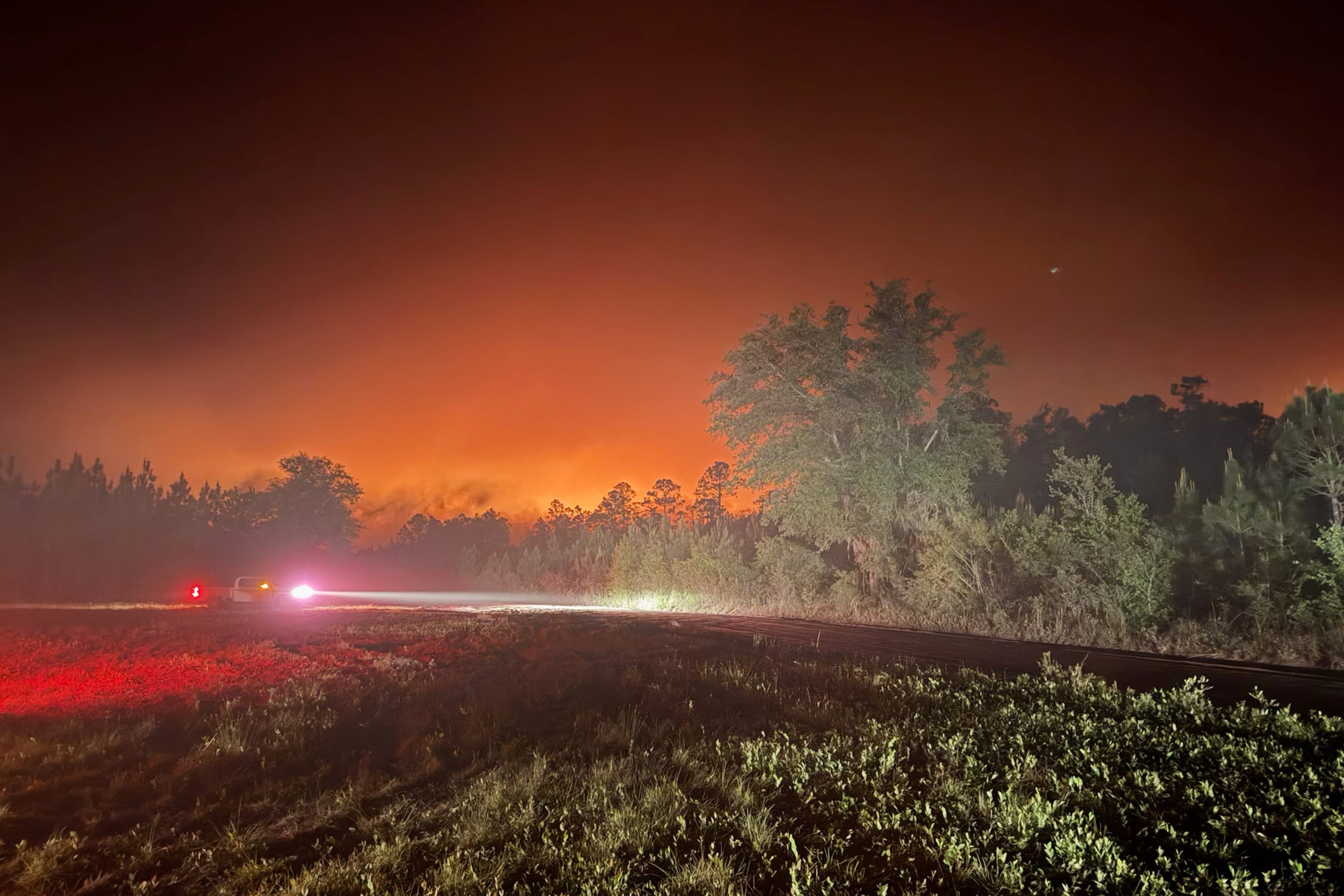 This photo provided by the Georgia Department of Natural Resources shows firefighters responding to the Pineland Road Fire in southeast Georgia on Monday, April 20, 2026. (Georgia Department of Natural Resources via AP)