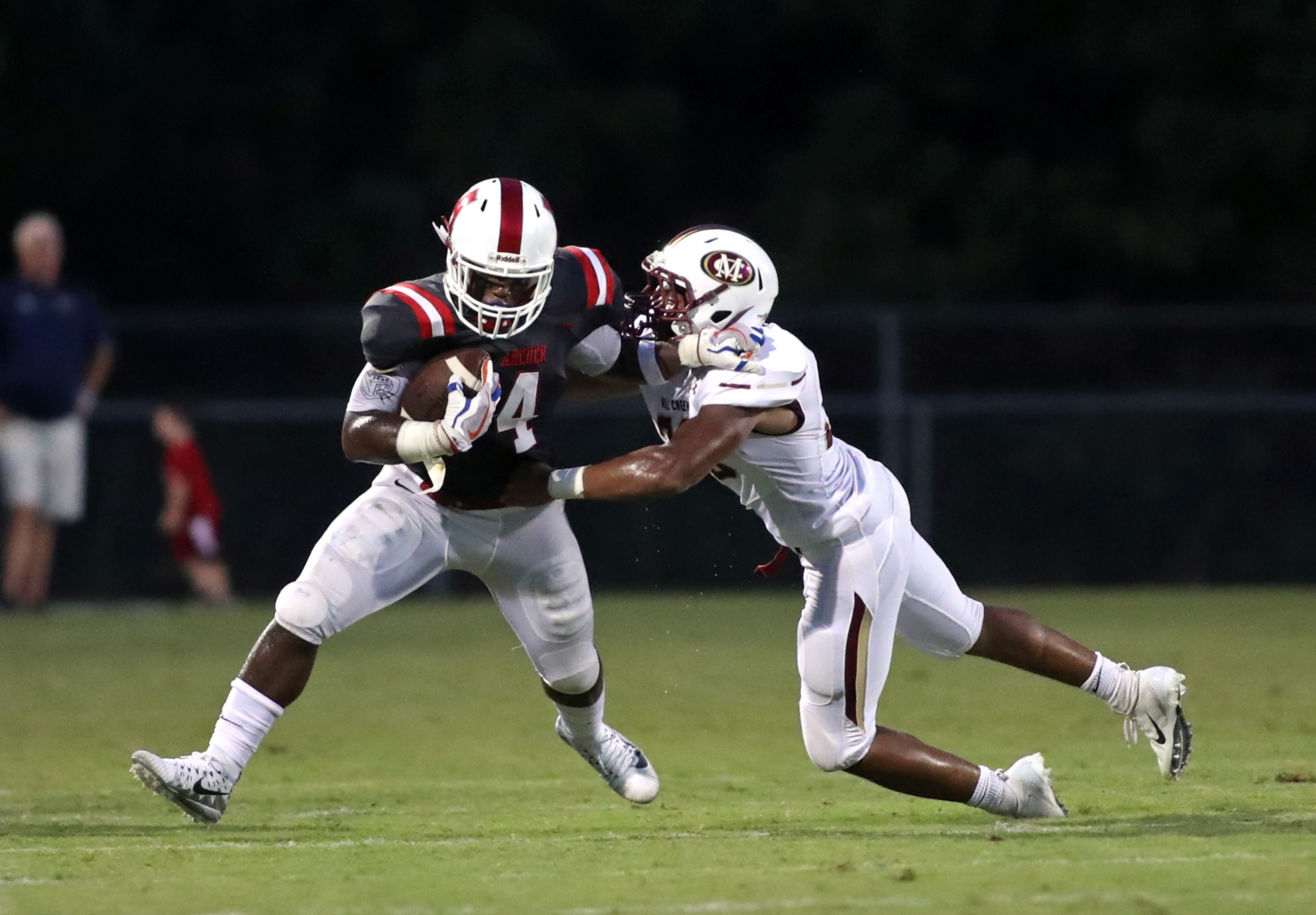Archer running back Emmanuel Michel (4) gets tackled by Mill Creek linebacker RJ Smith (36) in the second quarter of Friday's game. (Jason Getz/Special)