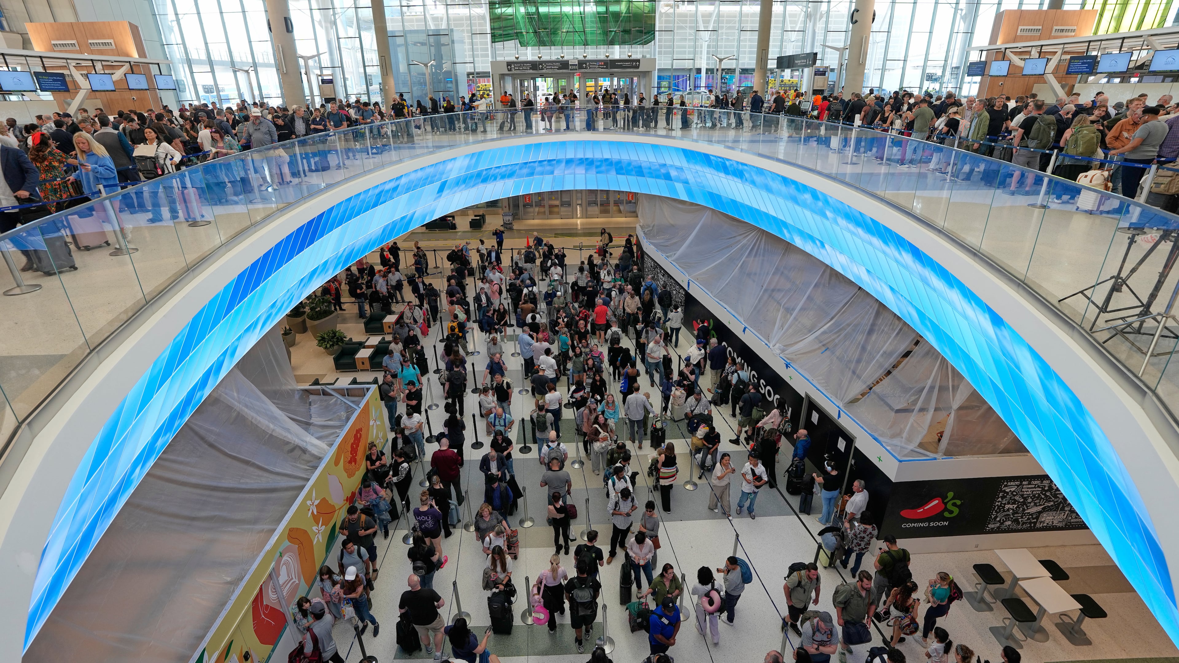 Travelers wait in long security checkpoint lines at George Bush Intercontinental Airport Friday, March 27, 2026, in Houston. (AP Photo/David J. Phillip)
