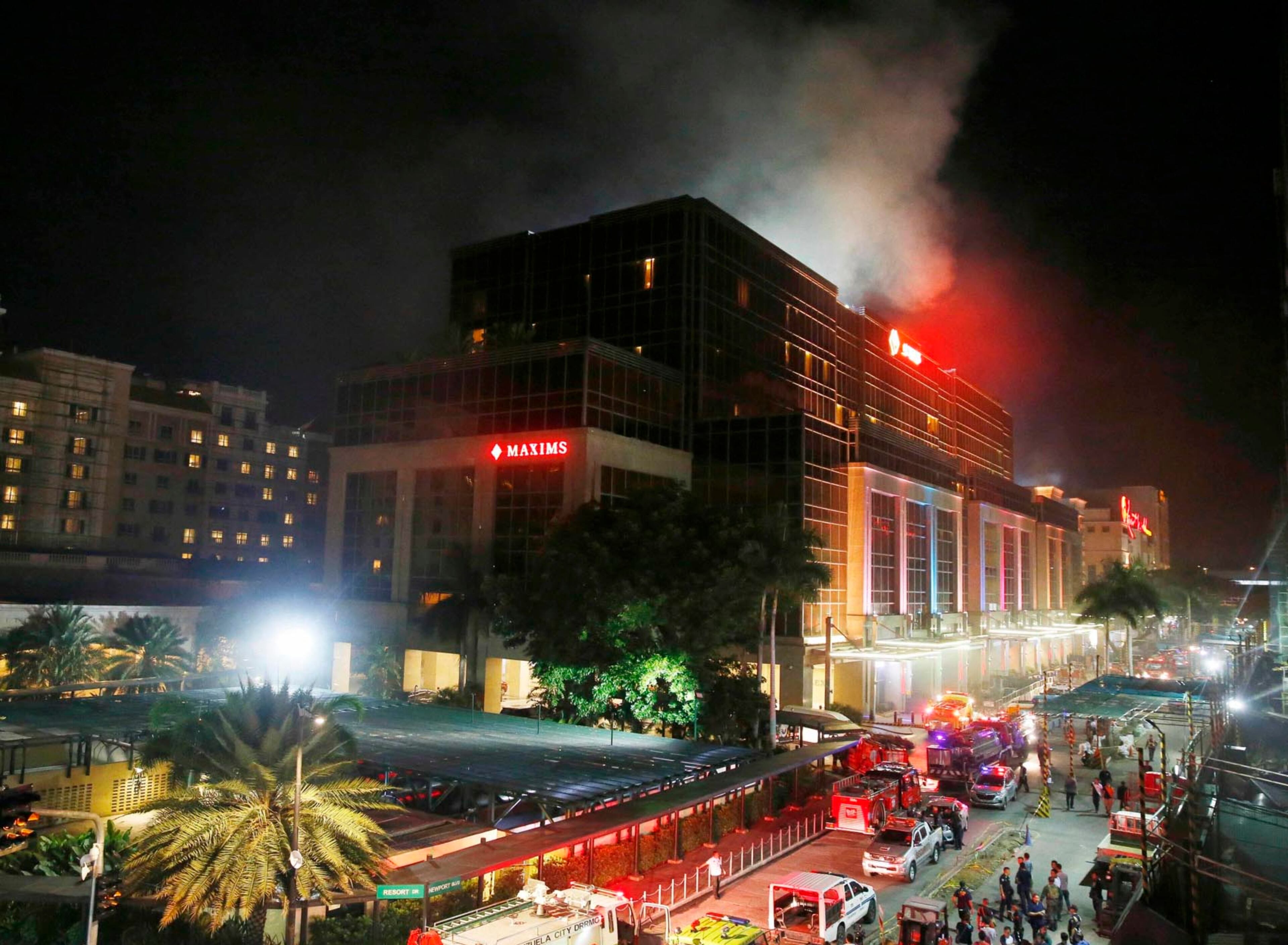 Smoke rises from the Resorts World Manila complex early Friday, June 2, 2017 in suburban Pasay city southeast of Manila, Philippines. Friday, June 2, 2017. Gunshots and explosions rang out early Friday at a mall, casino and hotel complex near Manila's international airport in the Philippine capital, sparking a security alarm amid an ongoing Muslim militant siege in the country's south. (AP Photo/Bullit Marquez)