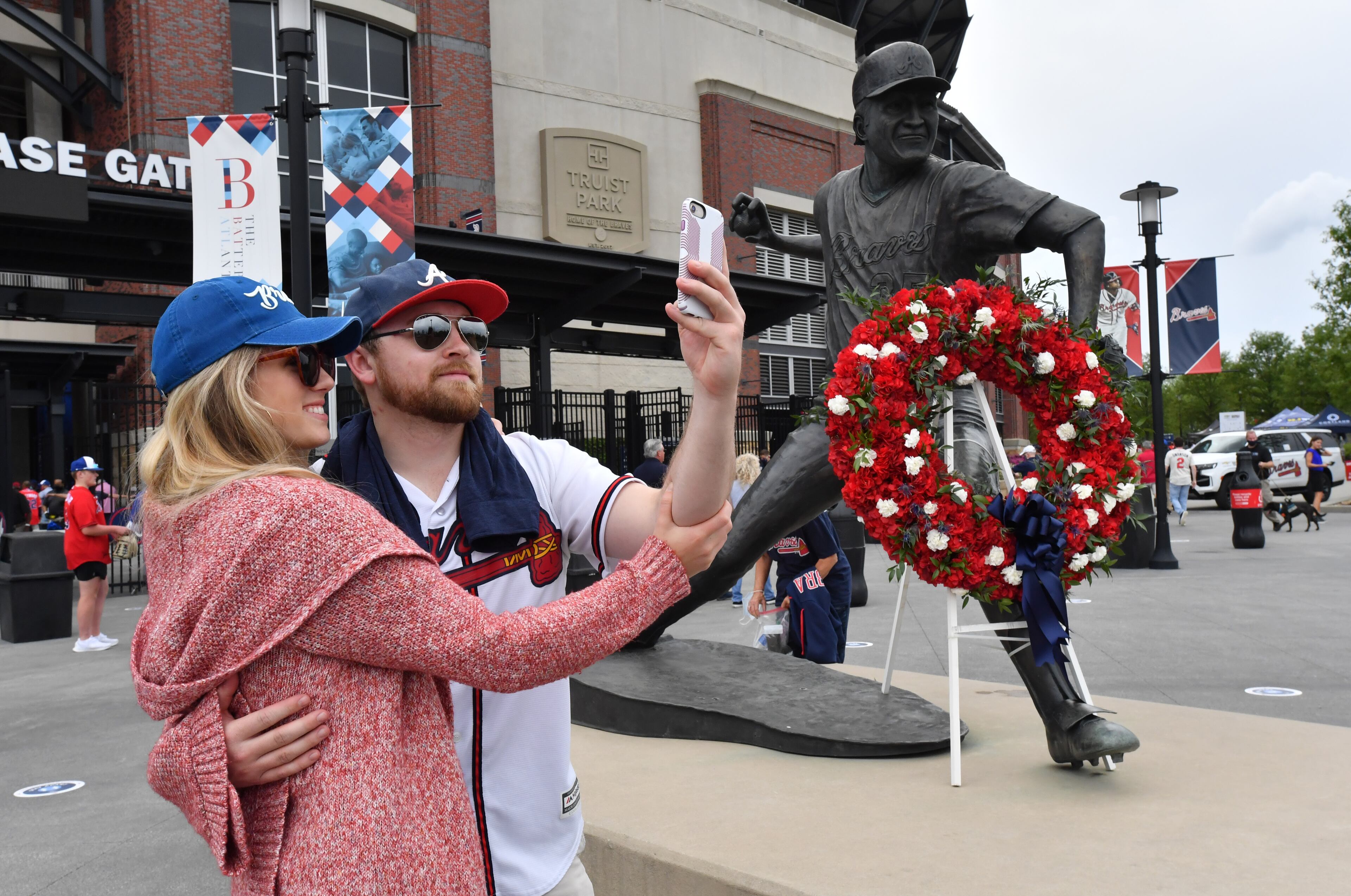 Lendahl Lagaly (left) and Duncan Anderson take a selfie next to the statue of Phil Niekro. (Hyosub Shin / Hyosub.Shin@ajc.com)
