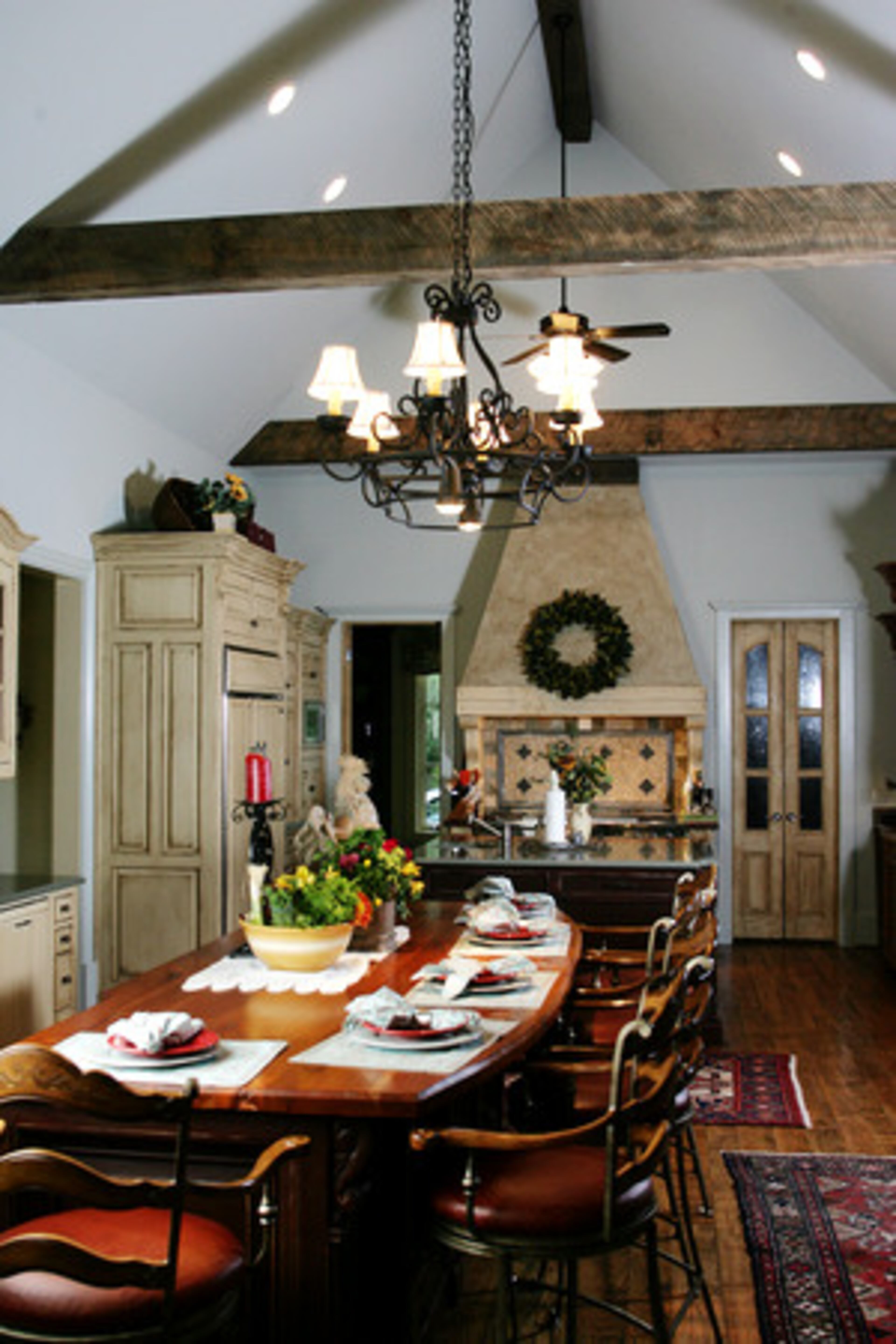 Structural wooden beams add a rustic accent to the roomy kitchen.