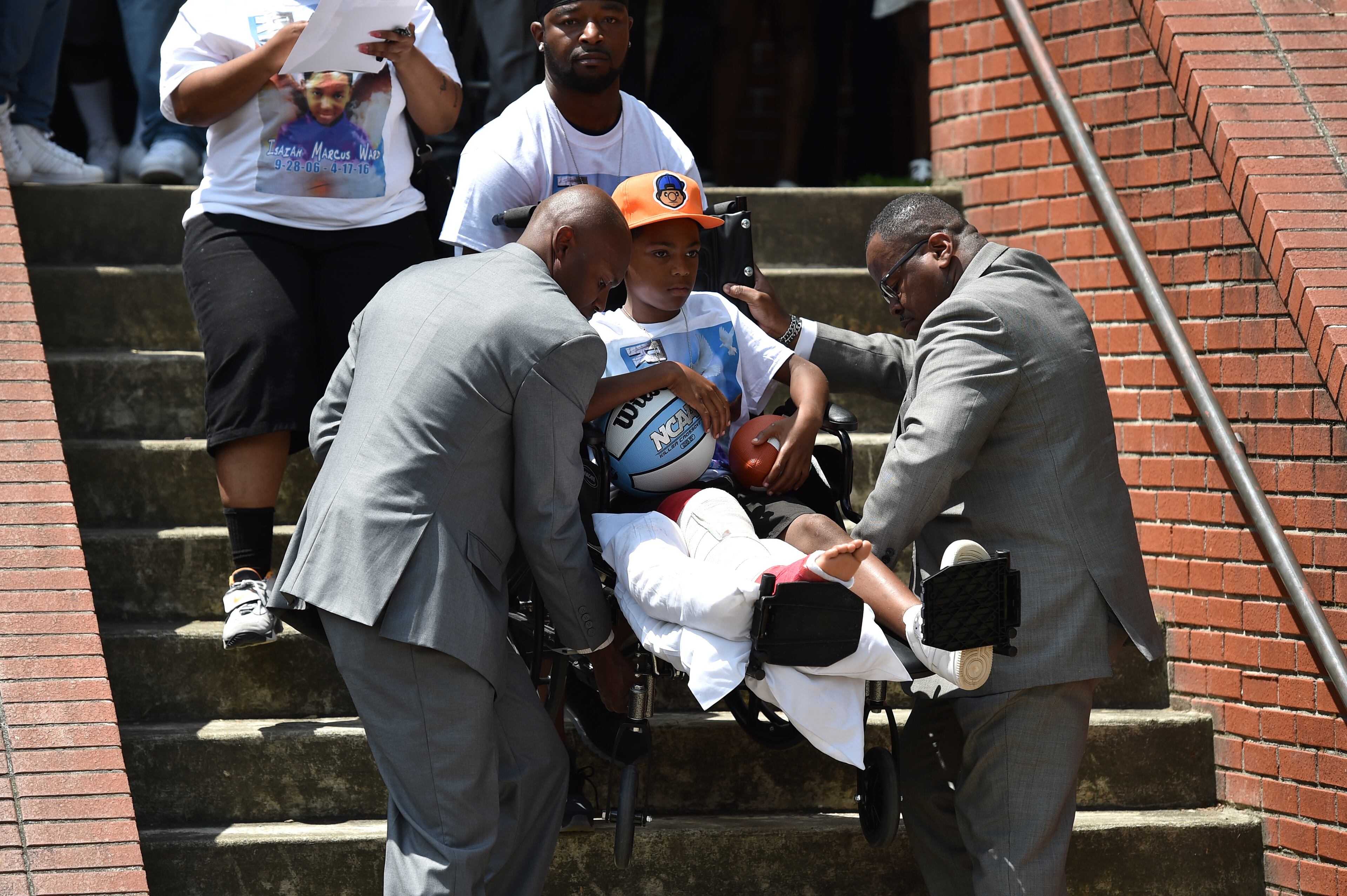 Roland Ward, in a wheelchair as a result of an accident that claimed the life of his brother Isaiah, is carried down the steps following the funeral service for Isaiah. The alleged driver, Ryan Lisabeth, has been charged with DUI on heroin and has an extensive criminal record. BRANT SANDERLIN/BSANDERLIN@AJC.COM