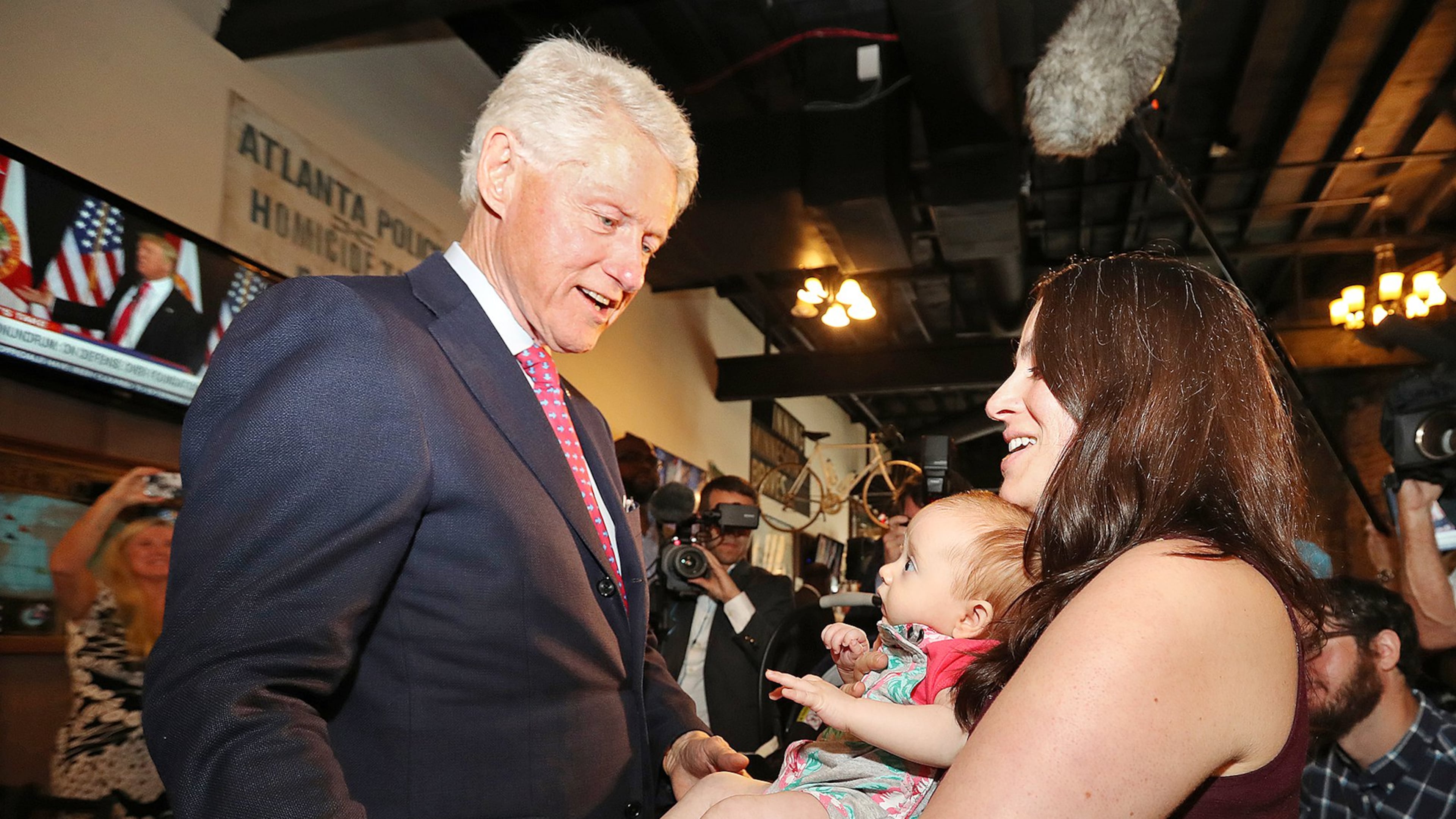 Former President Bill Clinton says hello to Megan Bartlett of Decatur and her 3-month-old daughter, Hannah Rice, as he works the crowd Wednesday during a campaign stop at Manuel’s Tavern. Curtis Compton /ccompton@ajc.com