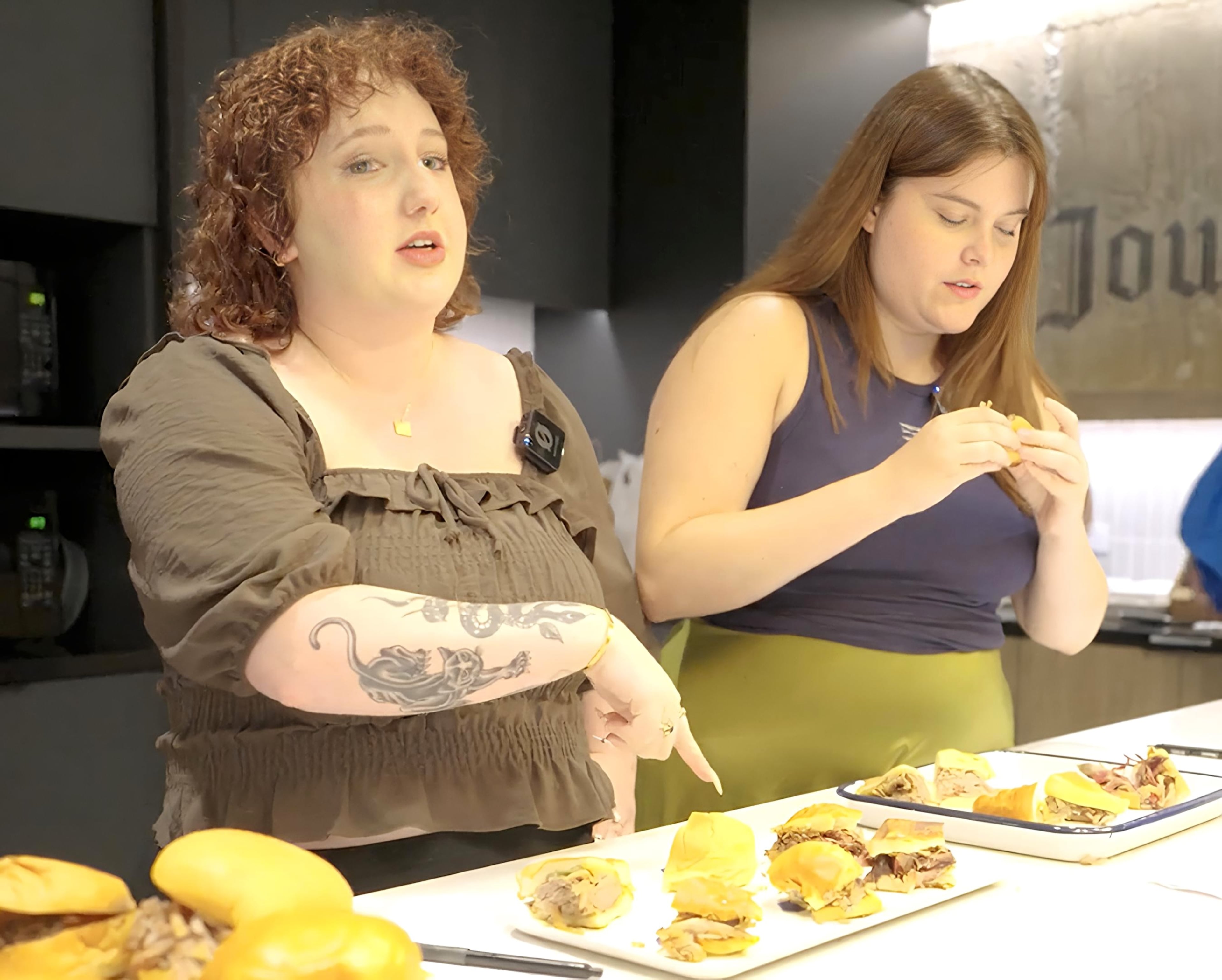 AJC interns Carson Bonner (left) and Kaitlyn Harvey (right) taste test pulled pork sandwiches on Thursday, June 18, 2026. (Ellen Rolfes/AJC)